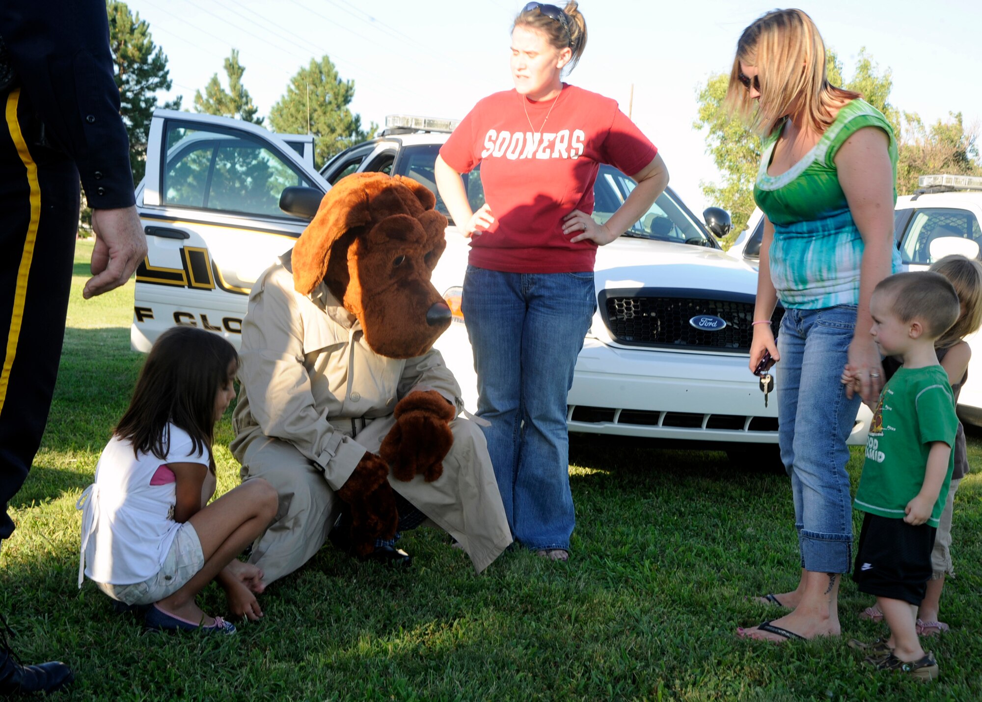 McGruff the Crime Dog gives 2-year old Brennan Emington information about what a crime dog does during  the National Night Out anti-crime event at Green Acres Park in Clovis, N.M., August, 2, 2010. The second annual event brought local, state and Cannon Air Force Base law enforcement personnel together to meet the public. Brennan, the son of Staff Sgt. David Emington, 27th Special Operations Security Forces Squadron, holds on to his mother's, Erica Emington, hand. (U.S. Air Force photo by Greg Allen)