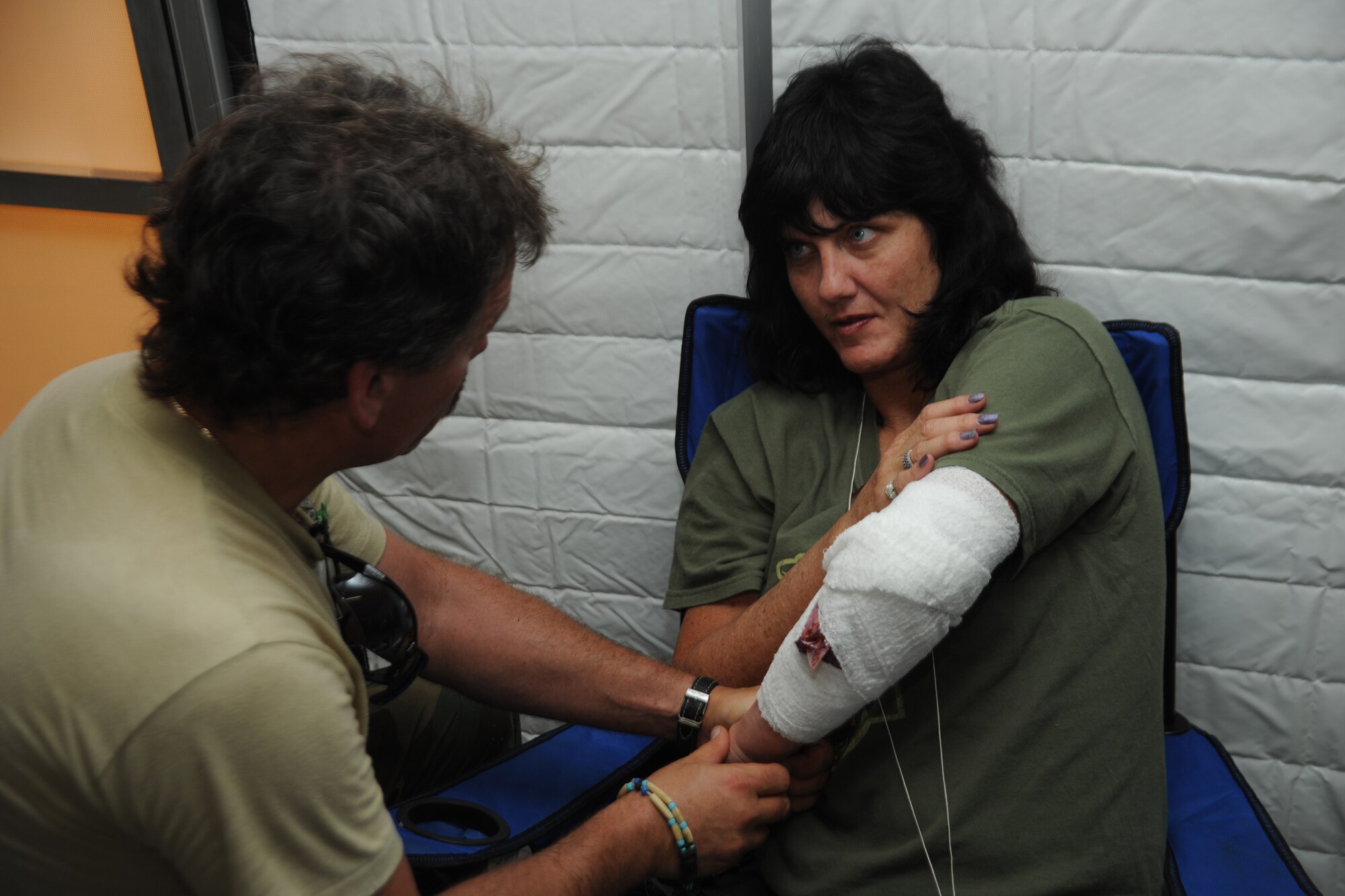 Dr. Michael Kane, a local civilian physician participating in Eagle Flag, treats a shrapnel arm wound on a civilian role player Aug. 5 at Joint Base McGuire-Dix-Lakehurst. Hundreds of civilian responders and government officials participated in the exercise for the first time to test the region’s ability to respond to a major hurricane in New Jersey. (U.S. Air Force photo by Staff Sgt. Zachary Wilson/Released.)