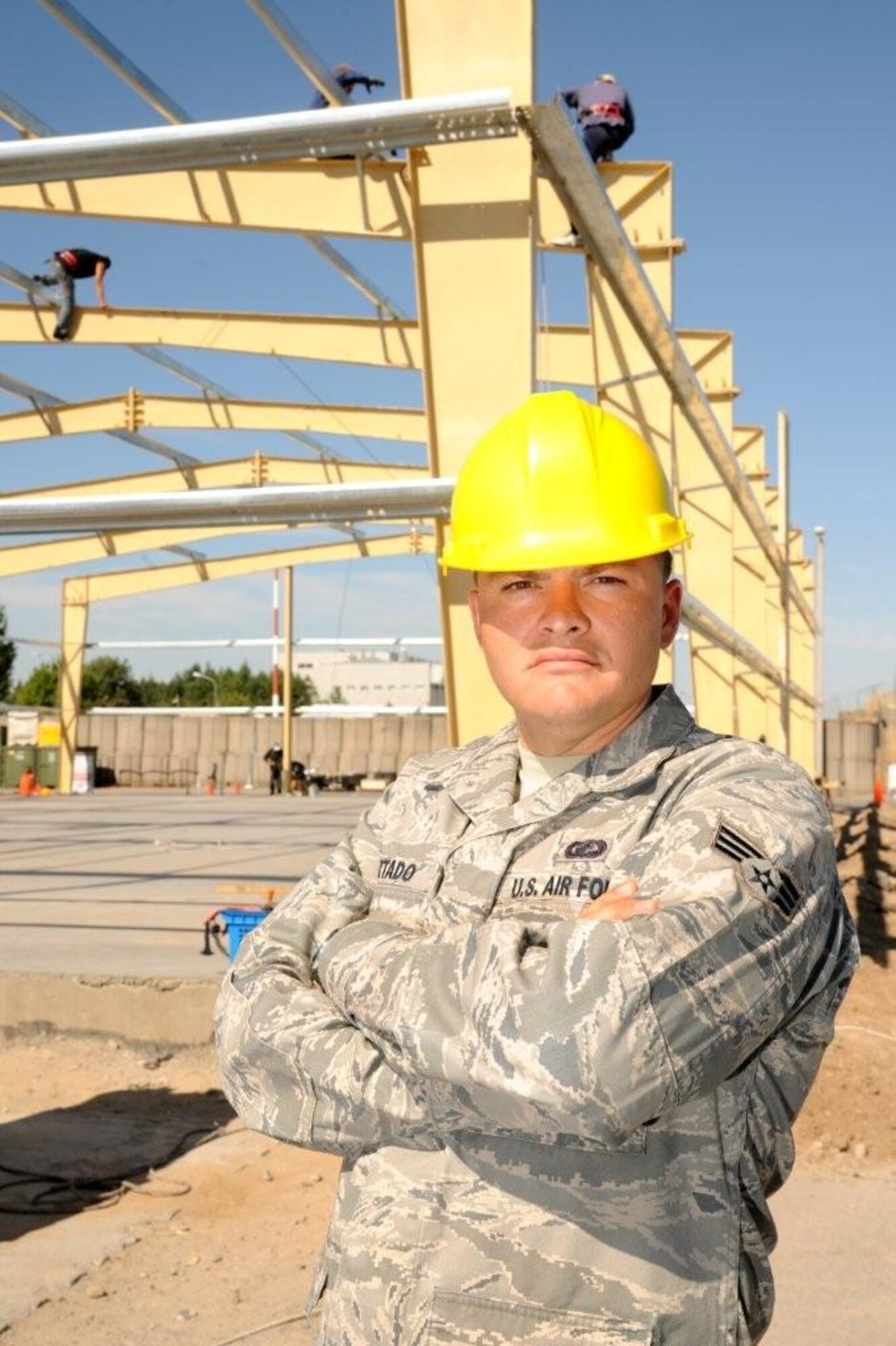 Senior Airman Eric Hurtado, 319th Contracting Squadron, takes a moment to pose for a photo while performing his duties during a deployment earlier this year. Part of Airman Hurtado’s job is to ensure construction projects are completed according to their contract agreement. (Courtesy photo)