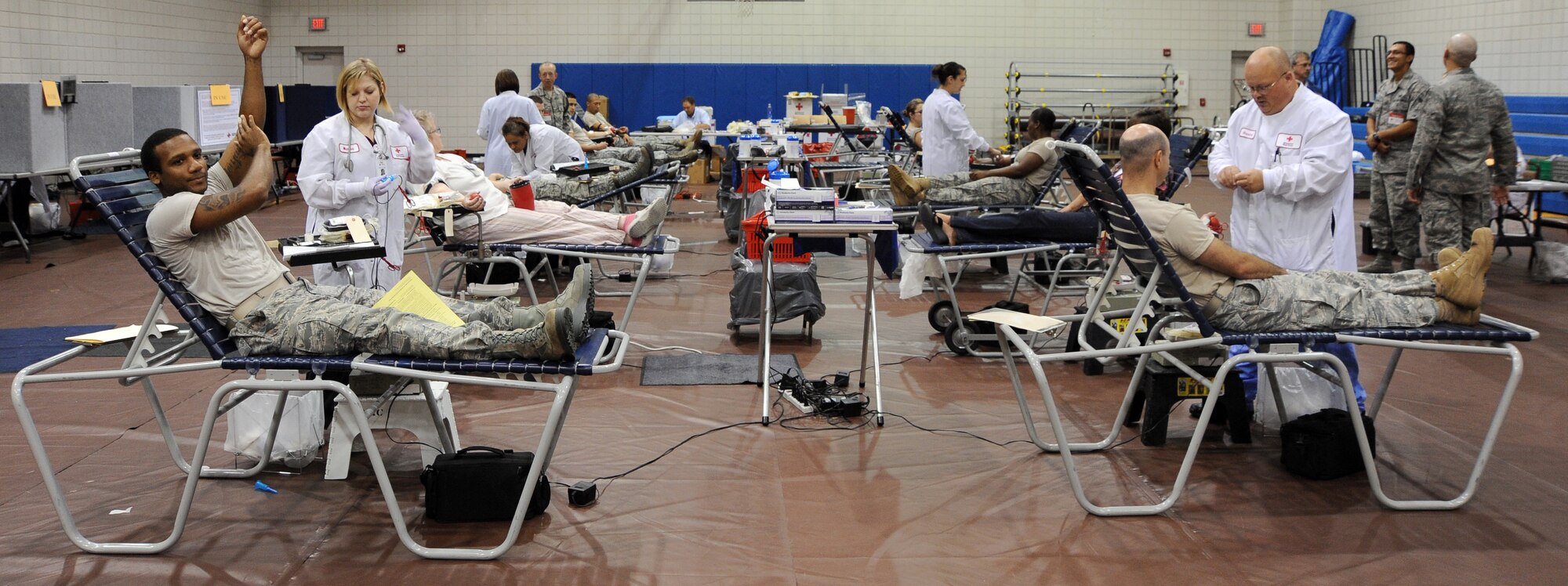 Team McConnell Airmen give blood at the Robert J. Dole Community Center July 30, 2010, McConnell Air Force Base, Kan. One pint of blood can save up to three servicemembers. This year’s blood drive was hosted by the Company Grade Officer Council who organized more than 60 volunteers. (U.S. Air Force photo/Senior Airman Courtney Witt)
