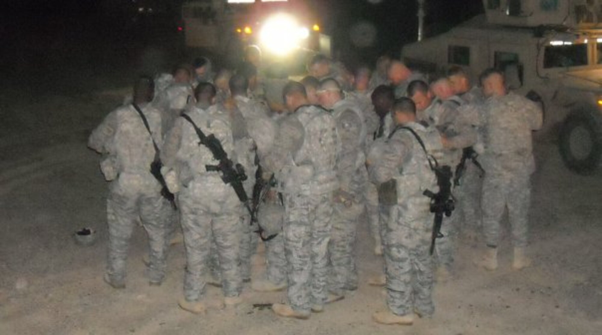 The 70th Medium Truck Detachment gathers for a prayer before a convoy mission, June 20, 2009, Forward Operating Base Kalsu, Iraq.  McConnell’s 22nd Logistics Readiness Squadron vehicle operations unit has had personnel assigned to 36 Joint Expeditionary Taskings to Arifjan, Kuwait.  As a whole unit, they have moved more than 936,000 tons of cargo, accomplished 540 outside the wire missions and drove 1.4 million miles throughout treacherous Iraqi roads.  The vehicle operations unit deployments average a total of nine months, to include basic combat convoy course training at Camp Bullis, Texas.  (courtesy photo)