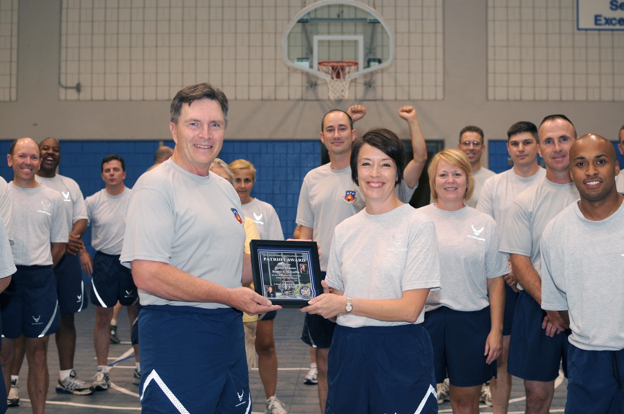 McGHEE TYSON AIR NATIONAL GUARD BASE, Tenn. -- Master Sgt. Bonnie S. McGuffin, EPME instructor, right, receives the TEC Patriot Award from Col. Richard B. Howard, commander, left, during the commander's monthly fitness training session at Wilson Hall on the campus of The I.G. Brown Air National Guard Training and Education Center here, July 28, 2010.  (U.S. Air Force photo by Master Sgt. Kurt Skoglund/Released)