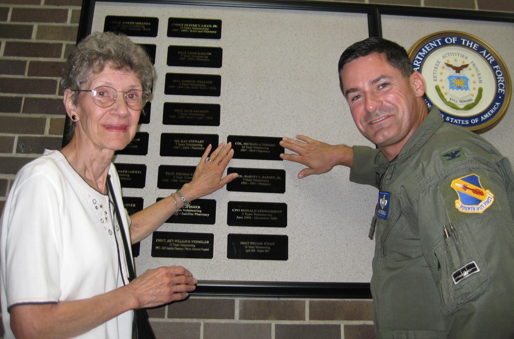 SEYMOUR JOHNSON AIR FORCE BASE, N.C.M -- Joan Todaro and Col. Shawn Pederson place a plaque commemorating retired Col. Michael Todaro’s volunteer service on the Volunteer Memorial Wall in the base exchange here July 30, 2010. After retiring from the military, Col. Michael Todaro’s commitment to his fellow servicemembers and their families did not end, he continued his service by volunteering on base for another 24 years. Colonel Pederson is the 4th Fighter Wing vice commander. (U.S. Air Force photo/Tech. Sgt. Tammie Moore) 