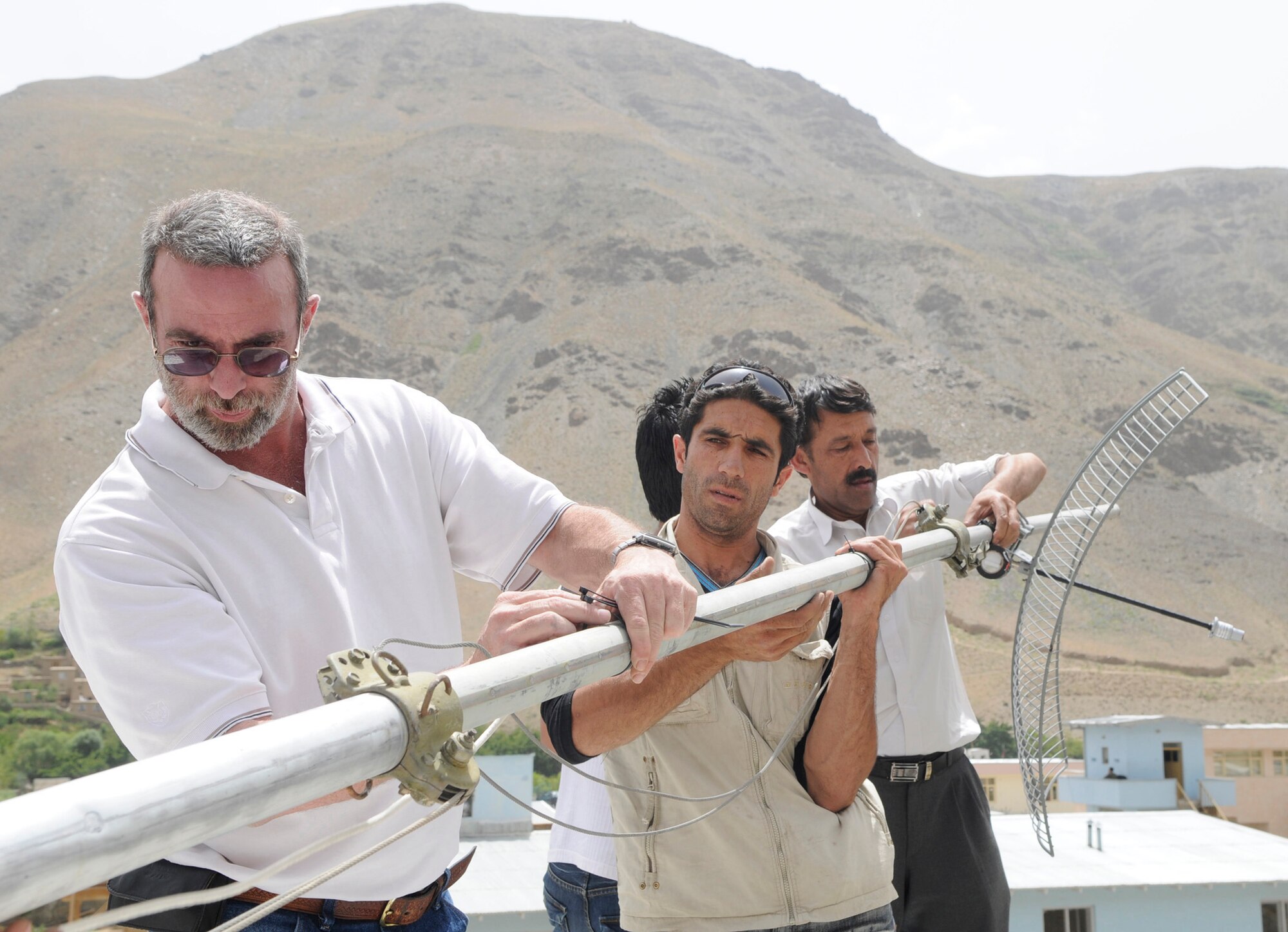Zach Morton, Deputy Radio Technical Advisor from Internews, a Peoria Ill. native, and a team of installers upgrade Radio Khurasan in Panjshir, Afghanistan from a wired connection to wireless by installing a new antenna.  Internews is an international media development organization whose mission is to empower local media worldwide to give people the news and information they need, the ability to connect, and the means to make their voices heard.  This antenna provides the station with increased wireless bandwidth and allows the radio station to stream their broadcast real time over the internet.  (Photo by U.S. Air Force Tech. Sgt. Sean M. White, PRT Panjshir Public Affairs Photographer)