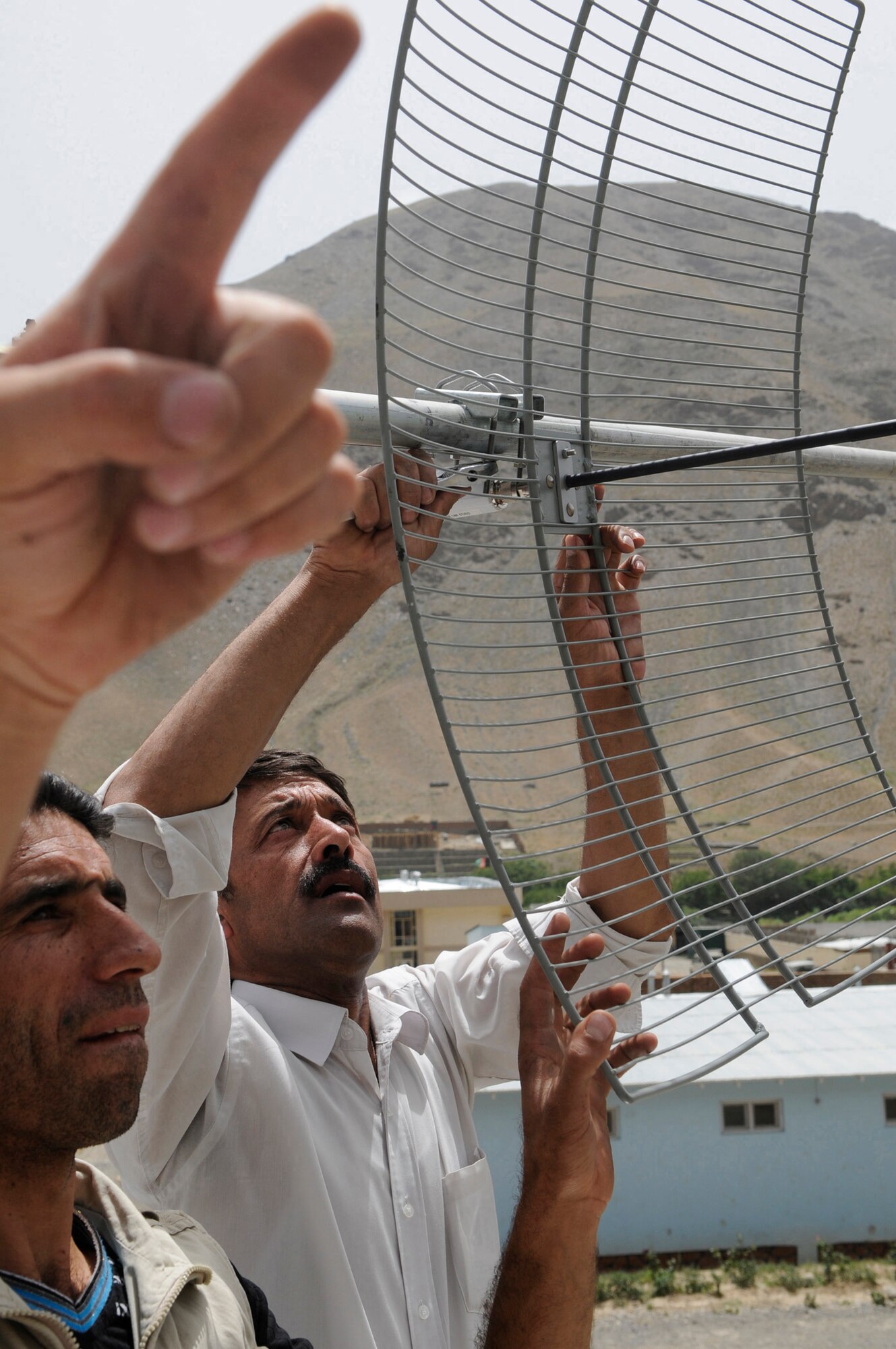 An installation team from the Internews office in Kabul, upgrades Radio Khurasan  in Panjshir, Afghanistan from a wired connection to wireless by installing a new antenna.  Internews is an international media development organization whose mission is to empower local media worldwide to give people the news and information they need, the ability to connect, and the means to make their voices heard.  This antenna provides the station with increased wireless bandwidth and allows the radio station to stream their broadcast real time over the internet.  (Photo by U.S. Air Force Tech. Sgt. Sean M. White, PRT Panjshir Public Affairs Photographer)