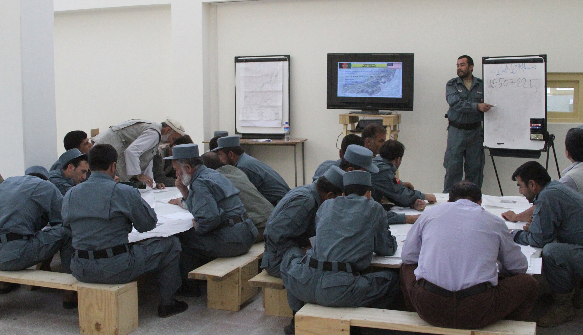 Afghan National Police Capt. Safat Ullah Sangee, Panjshir Operations Coordination Center-Provincial, teaches a map and compass reading techniques class July 13. This class was the second day of Sangee?s three-day course at the Rokha Police Headquarters. Some of the things Sangee taught included how to use a protractor with a map, give grid coordinates, find grid coordinates, identify terrain features and measure distance between points. (Photo by U.S. Air Force 2nd Lt. Jason Smith, PRT Panjshir Public Affairs)