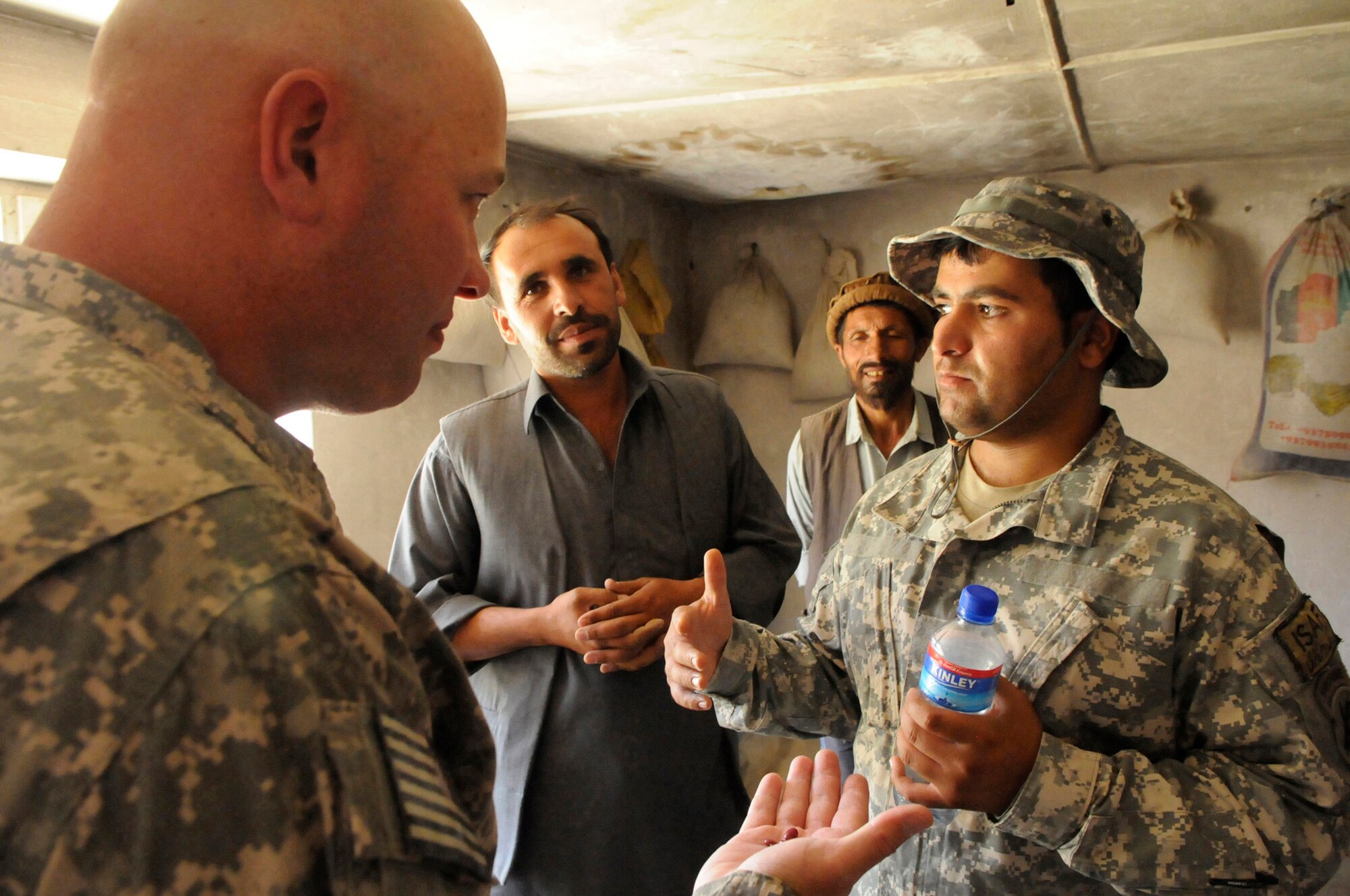 U.S. Army Lt. Col. Jeffrey Casada, Kentucky National Guard Agri-Business Development Team leader discusses with Shah Mirza, the Dashtak Demonstration Farm manger, through an interpreter, about what is being done with the produce harvested this season.  Along with being stored for the winter the harvest is also being used to feed the workers families and livestock.  The farm established in 2008, is a way for the American experts to demonstrate techniques to the locals in order to increase crop yields.  (Photo by U.S. Air Force Tech. Sgt. Sean M. White, PRT Panjshir Public Affairs Photographer)