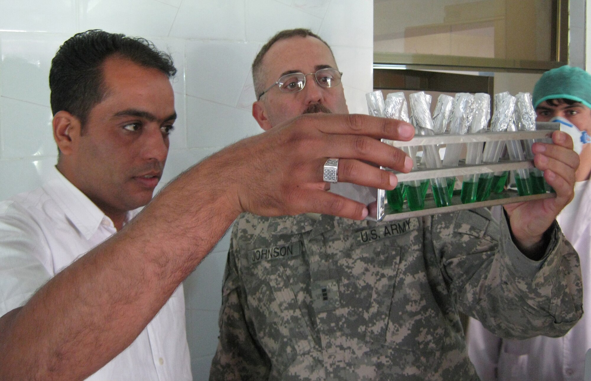 100711-F-1110S-028: Ali Rezayi, Panjshir Beverage Industry LTD quality control manager, shows Army Chief Warrant Officer Peter Johnson, 72nd Medical Detachment Veterinary Services, one of the chemical tests the plant runs on bottled water. Johnson spent July 11 pre-auditing the water bottling plant in the Khenj District of the Panjshir Valley, Afghanistan. (Photo by U.S. Air Force 2nd Lt. Jason Smith, PRT Panjshir Public Affairs)