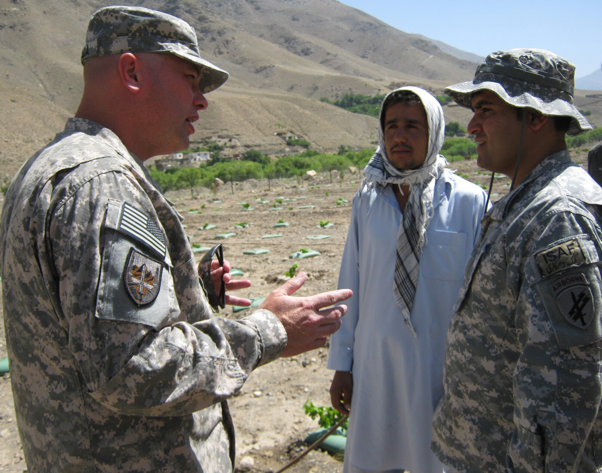 U.S. Army Lt. Col. Jeffrey Casada, Kentucky National Guard Agri-Business Development Team leader with Provincial Reconstruction Team Panjshir (left), talks, through an interpreter, to the manager of the Astana Demonstration Farm, Shafe Makli, in the Panjshir Province, Afghanistan. The farm, initially established in 2008, is a way for the American experts in agriculture to share their knowledge of farming with Afghans. (Photo by U.S. Air Force 1st Lt. Holly Hess, PRT Panjshir Public Affairs)                   