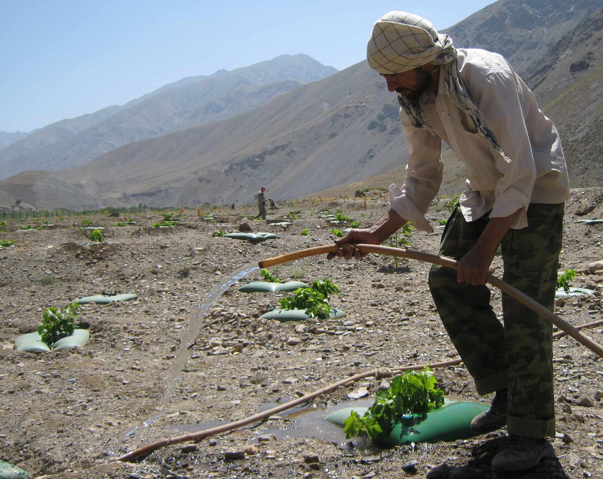 An Afghan worker waters grape plants at the Astana Demonstration Farm in the Panjshir Province of Afghanistan. The farm, initially established in 2008, is a way for the American experts in agriculture at Provincial Reconstruction Team Panjshir to share their knowledge of farming with Afghans. (Photo by U.S. Air Force 2nd Lt. Jason Smith, PRT Panjshir Public Affairs)