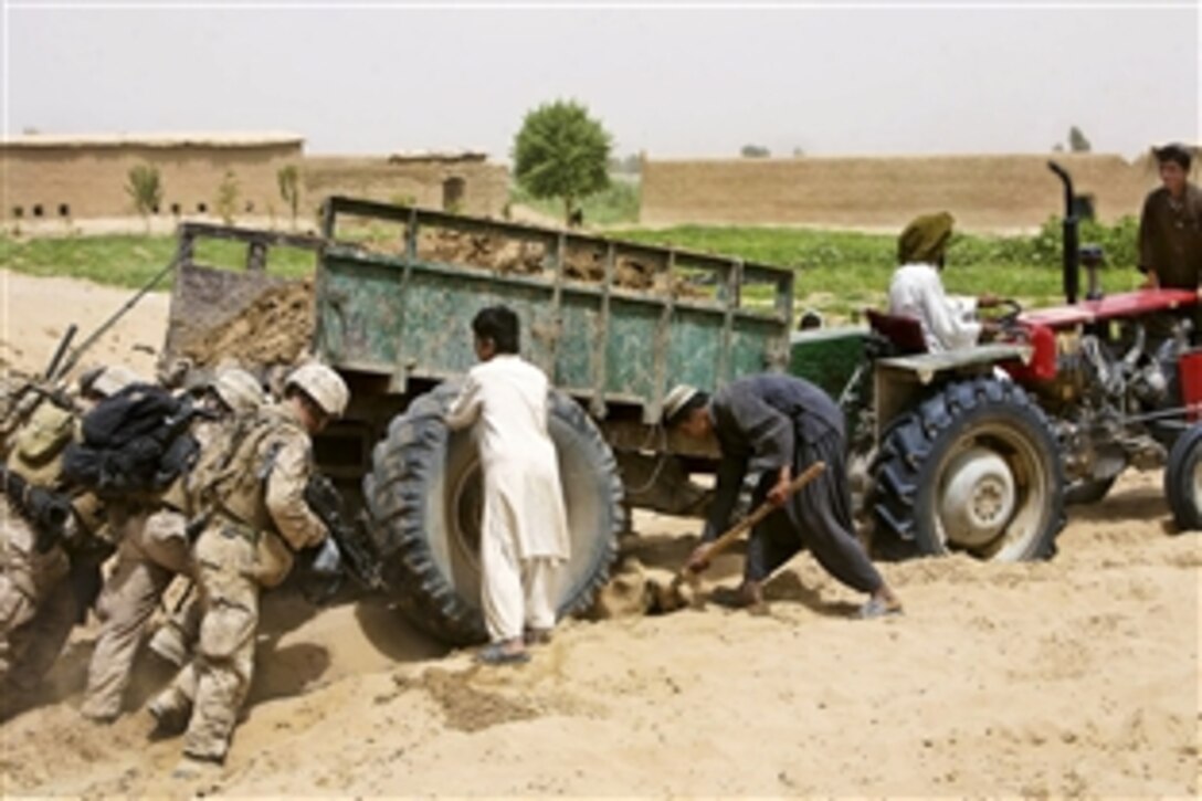 U.S. Marines push a farmer's tractor out the sand near Patrol Base Amir Agha, Afghanistan, July 31, 2010. The Marines are assigned to the 3rd Battalion, 1st Marine Regiment, Regimental Combat Team 7.