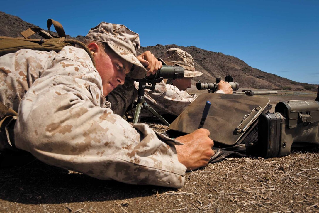 Cpl. Jason Johnson, a student with Scout Sniper School, School of Infantry West, Detachment Hawaii, and a reconnaissance Marine with Company A, 3rd Reconnaissance Battalion, from Camp Schwab, Okinawa, Japan, calculates a shooting adjustment while Sgt. Justin Leibach, a recon Marine with Company A, 3rd Recon Bn., fires his M40A3 sniper rifle during an unknown distance qualification course at Range Training Facility Kaneohe Bay on Marine Corps Base Hawaii Aug. 5. Johnson and Leibach were among the infantrymen and recon Marines attending the 10-week Scout Sniper Basic Course in order to earn the military occupational specialty of 0317, scout sniper.