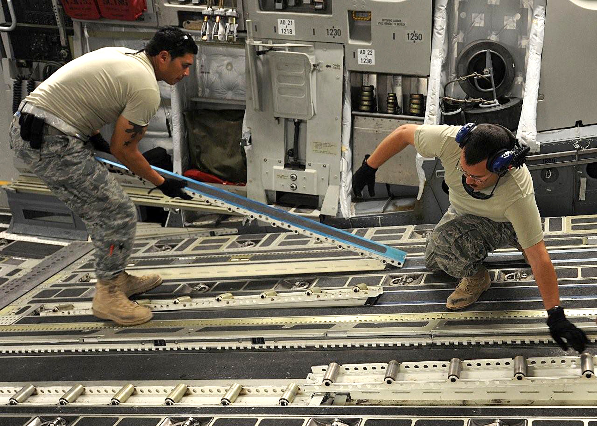 Tech. Sgt. Edwin McCrann, left, and Master Sgt. Michael Silva install omni rollers on the ramp of a C-17, just one of their many maintenance duties while deployed to Southwest Asia.  Both NCOs are Reservists deployed from the 446th Aircraft Maintenance Squadron, Joint Base Lewis-McChord, Wash. (U.S. Air Force photo/Senior Airman Michael Means)