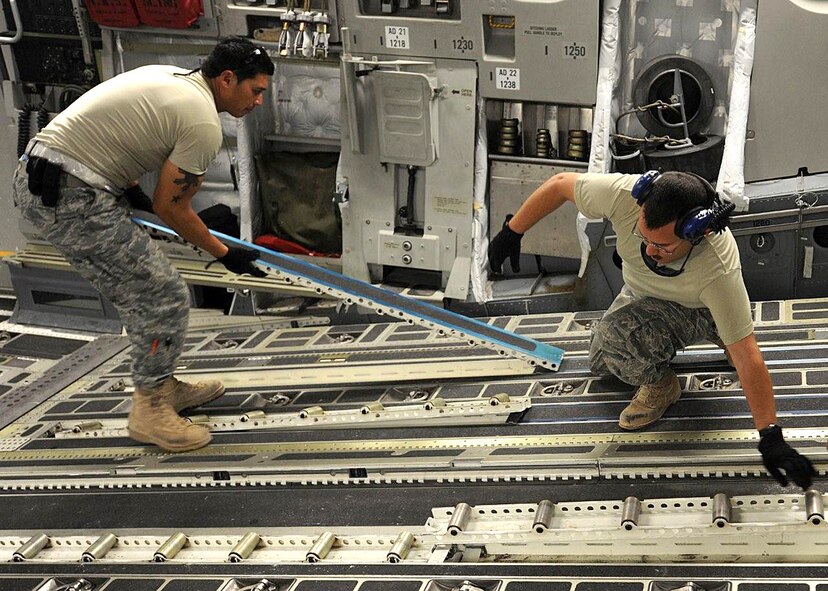 Tech. Sgt. Edwin McCrann, left, and Master Sgt. Michael Silva install omni rollers on the ramp of a C-17, just one of their many maintenance duties while deployed to Southwest Asia.  Both NCOs are Reservists deployed from the 446th Aircraft Maintenance Squadron, Joint Base Lewis-McChord, Wash. (U.S. Air Force photo/Senior Airman Michael Means)
