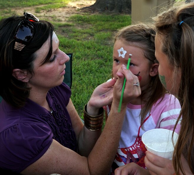 BARKSDALE AIR FORCE BASE, La. -- Jessica Kelly, Barksdale Enlisted Spouse Group member, paints the face of Abby Beasley, 5-years-old, during Barksdale's third annual National Night Out Aug. 3. The BESG painted the faces of more than 30 kids. (U.S. Air Force photo by Senior Airman La'Shanette V. Garrett)(RELEASED)