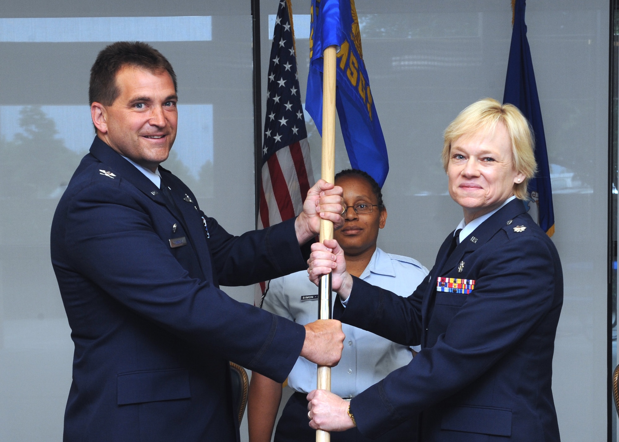 MOUNTAIN HOME AIR FORCE BASE, Idaho -- Col. Kevin Connolly, 366th Medical Group commnader, passes the guidon to Lt. Col. Judy Stoltmann, 366th Medical Surgical Squadron commander, during a Change of Command Ceremony in the Medical Group training room July 26. Col. Julia Stoshak, former 366th Medical Surgical Squadron commander, will take command of the 81st Medical Operations Squadron at Keesler Air Force Base, Mississippi. (U.S. Air Force photo by Airman 1st Class Debbie Lockhart)