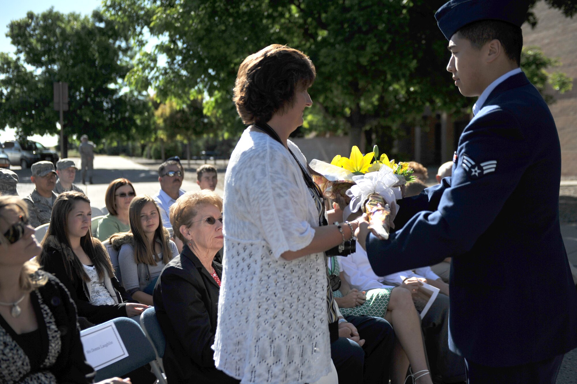 MOUNTAIN HOME AIR FORCE BASE, Idaho - An Airman of the 366th Medical Operations Squadron presents Mrs. Laughlin with a token of appreciation for all the service and dedication as a military spouse during a change of command ceremony June 22. The gift of flowers is the traditional show of appreciation to the families of the commanders who are leaving command to move on to a new assignment. (U.S. Air Force photo by Airman 1st Class Renishia Richardson)

