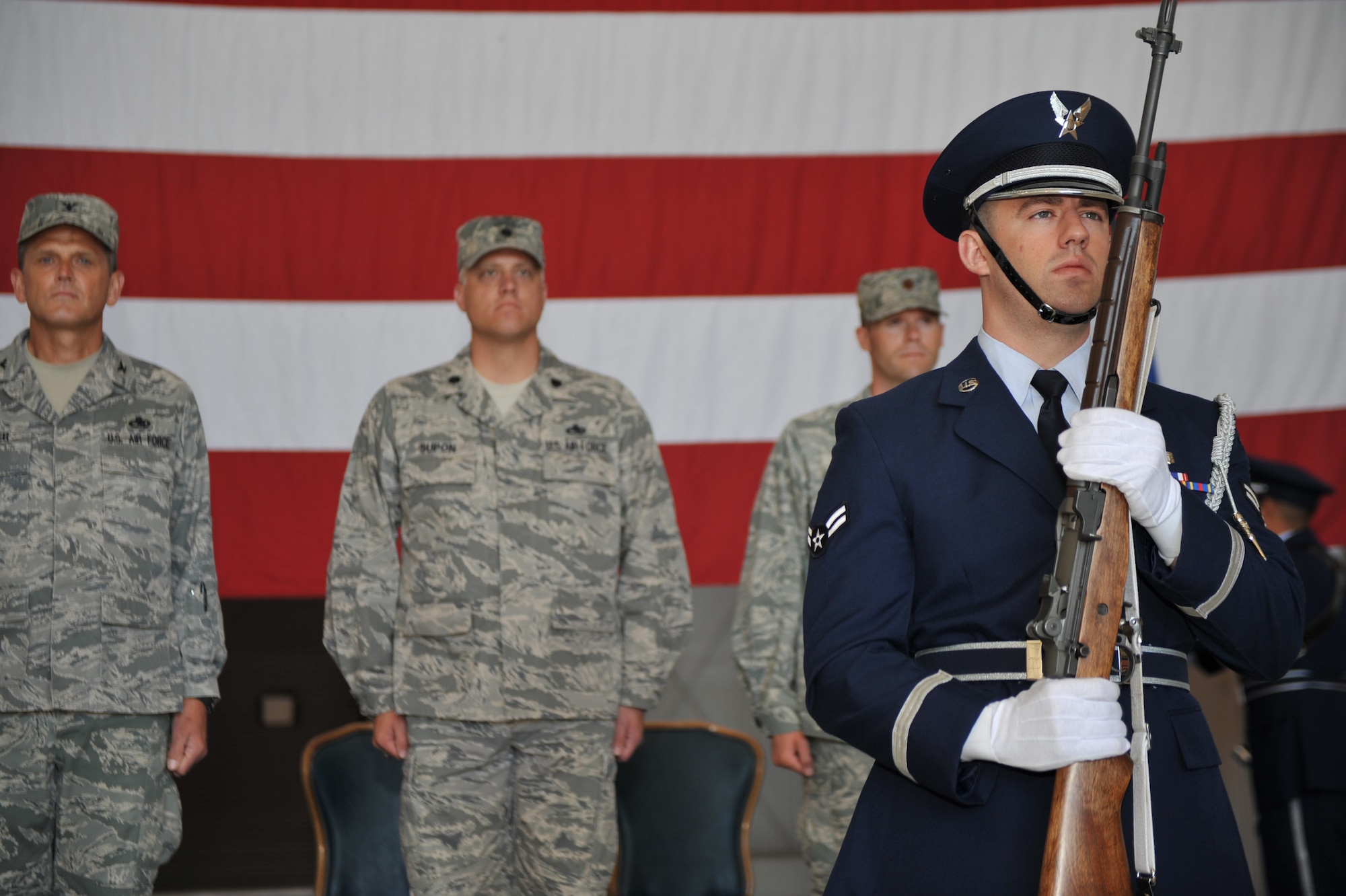 MOUNTAIN HOME AIR FORCE BASE, Idaho -- Airman 1st Class Lance Courtier, Mountain Home Air Force Base Honor Guard, stands at attention as other members retire the colors during a Change of Command Ceremony in hangar 1331, June 18. The 366th Equipment Maintenance Squadron welcomed new commander Maj. Charles Dunaway Jr. Maj Dunaway was previously a student at Army Command and General Staff College in Fort Leavenworth, KS.  (U.S. Air Force photo by Airman 1st Class Renishia Richardson)