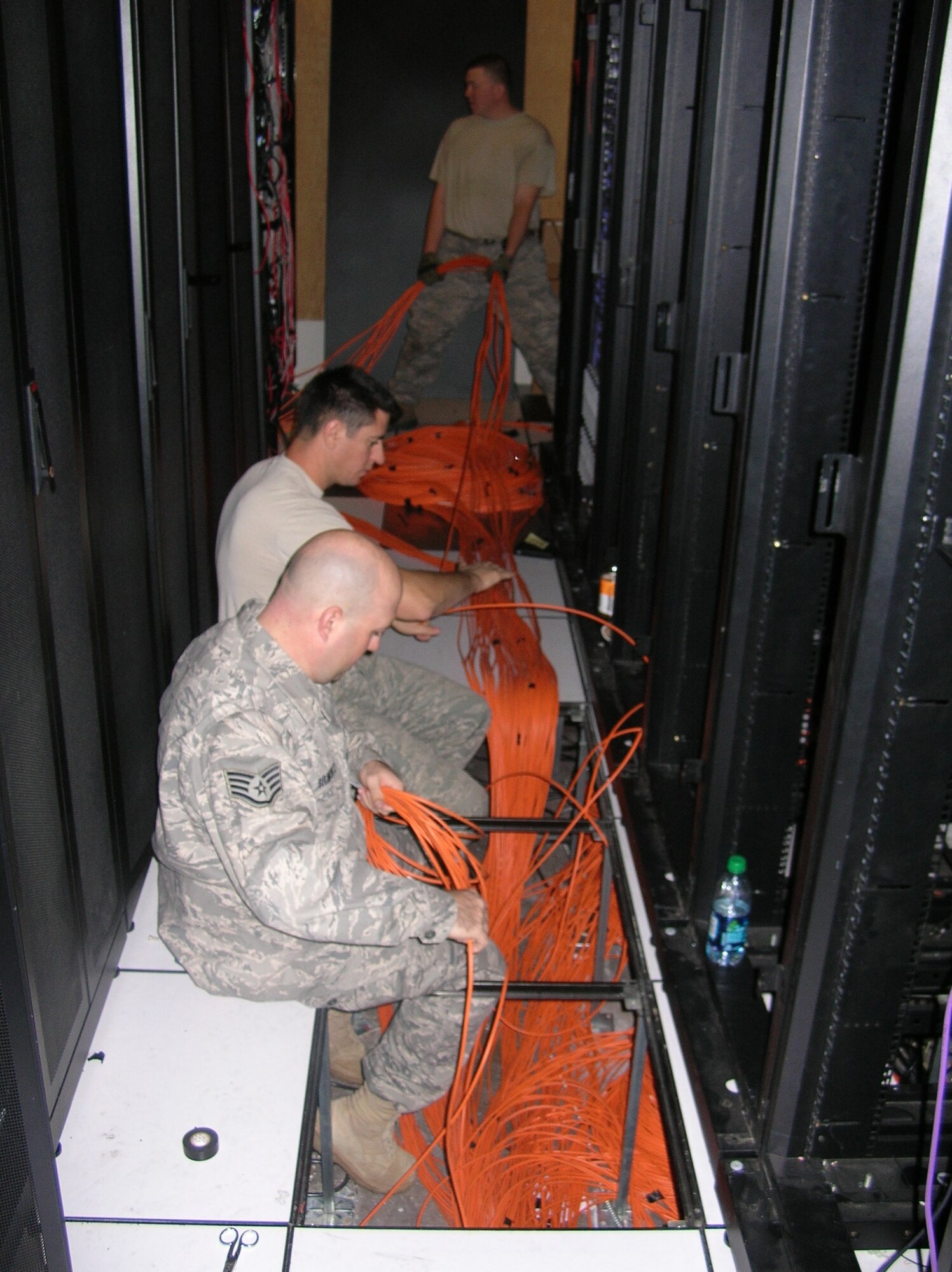 From front to back, Staff. Sgt. Sean Belmonte, Staff Sgt Lake Bouder and Senior Airman Michael Johnson, cable and antenna technicians, installed more than 40,000 feet of CAT 5 cable, 35,000 feet of fiber-optic cable and terminated more than 3,000 network cables for the Combined Air and Space Operations Center at Nellis AFB, Nev. (Air Force photo)