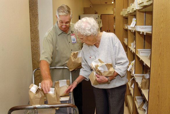 Jim Gordon and Sweetie Scholz file filled prescriptions in the 72nd Medical Group’s Pharmacy drive-through area. Retired from a military and civil service Air Force career, Mr. Gordon says working with people has made his four years of volunteering rewarding. Ms. Scholz has volunteered in several places here for approximately 20 years and she agrees with Mr. Gordon. “I feel good when I leave,” she said. “If I didn’t, I wouldn’t be here.” (Air Force photos by Margo Wright)