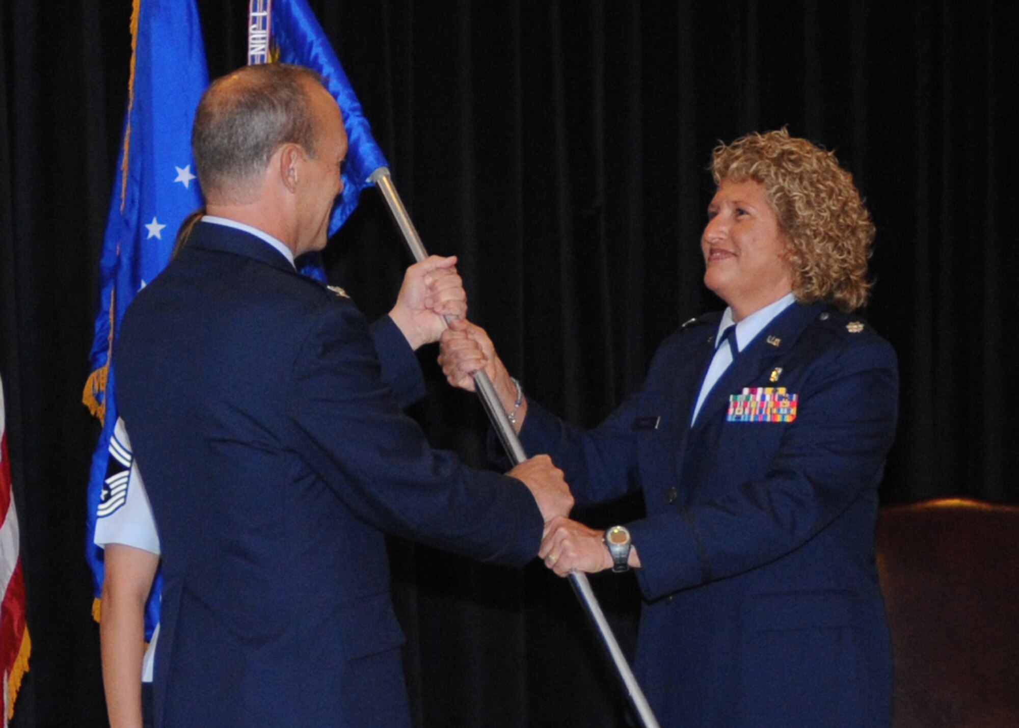 U.S. Air Force Lt. Col. Yolanda Rogers (right) assumes command of the 27th Special Operations Medical Operations Squadron from U.S. Air Force Col. Scott Corcoran, 27th Special Operations Medical Group commander, in a change-of-command ceremony Aug. 6, 2010. U.S. Air Force Lt. Col. James Reineke relinquished command of the 27th SOMOS. (U.S. Air Force photo by Airman 1st Class Maynelinne De La Cruz)(Released)