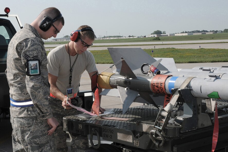 During Operation Grandstand, in preparation for the Operational Readiness Inspection which will be in October, Senior Airman (SRA) Benjamin Rogers (left) and SRA Brandon Bond (right) review ammunition forms on the west ramp of the 132nd Fighter Wing in Des Moines, Iowa, on August 6, 2010.  SRA Bond is delivering missiles to SRA Rogers, who will be loading them onto an F-16C aircraft.  (US Air Force photo/Staff Sgt. Linda E. Kephart)(Released)    