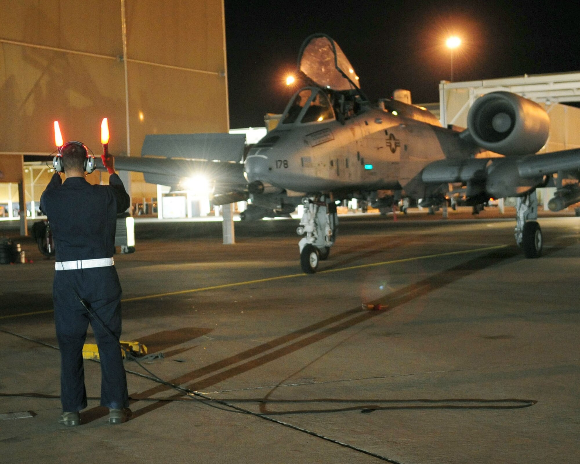 Airman 1st Class Jeff Gronemyer, an A-10C Thunderbolt II crew chief from the 355th Aircraft Maintenance Squadron at Davis-Monthan Air Force Base, Ariz., directs 1st Lt. Dan Griffin to his parking spot June 23, 2010, following his second night flight. Lieutenant Griffin is a student in the A-10C Pilot Initial Qualification course. . Upon completion of the course in August he will become a fully qualified A-10C attack pilot. (U.S. Air Force photo/Airman 1st Class Jerilyn Quintanilla)
