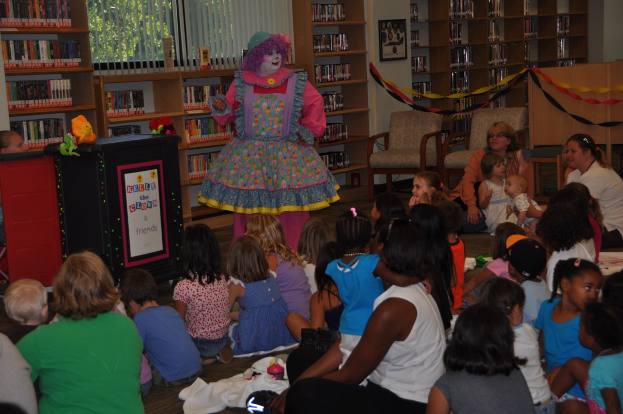Kelly the Clown teaches Travis youth about the importance of reading during the event. During the summer of 2010, the Department of Defense funded the first ever DoD-wide summer reading program. All Air Force, Navy, Army and Marine Corps libraries, who serve children, were offered funding support for the "Voyage to Book Island" summer reading program. (U.S. Air Force photo/Airman 1st Class Michael Battles.)