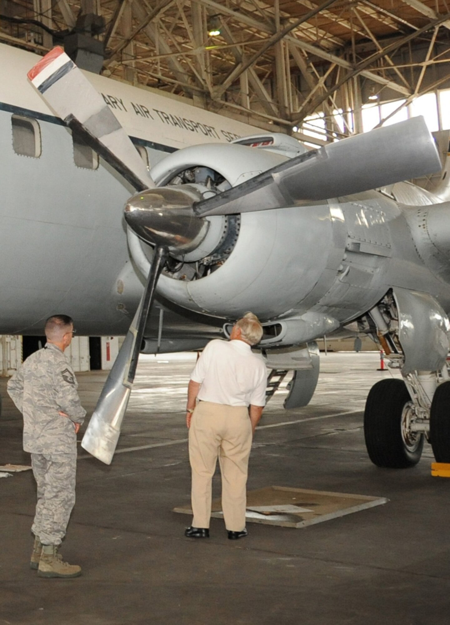 JOINT BASE MCUIRE-DIX-LAKEHURST, N.J. -- Senior Master Sgt. Christopher Hofrichter shows former crew member and retired flight mechanic John Wehrman around the C-118, Aug. 3, 2010. During the restoration, the propellers will be buffed, stripped of the Navy colors they are currently painted and repainted with the Air Force colors it had during its 11 years of operations with McGuire. (U.S. Air Force photo/James Hodges)