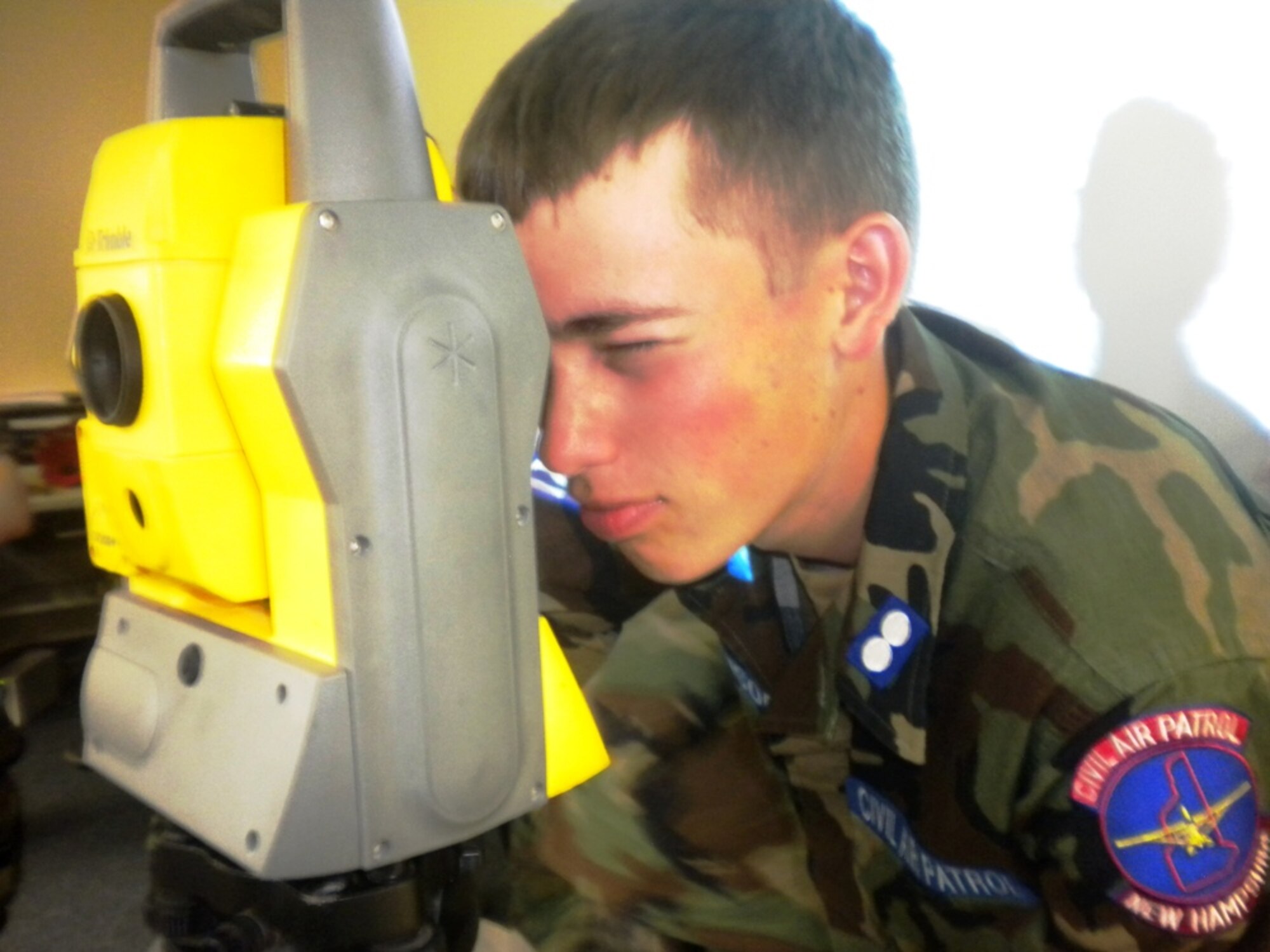At the Civil Air Patrol's Air Force Civil Engineering Academy at Tyndall, Cadet 1st Lt. Noah Johnson of New Hampshire's Lebanon Composite Squadron looks through a transit that would be used to survey a job site by Air Force engineering assistants. (Courtesy photo)
