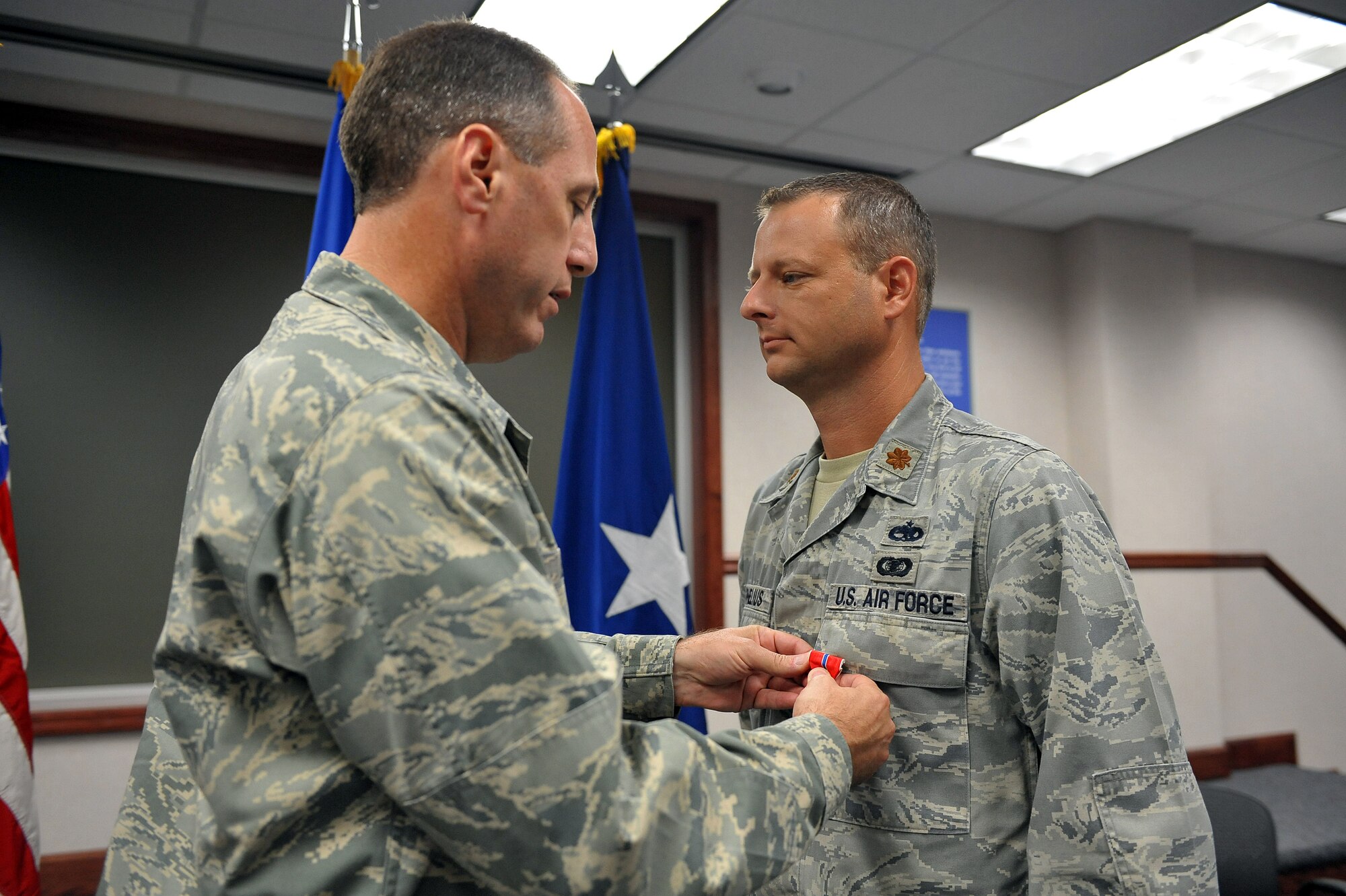 Maj. Wade Cornelius, right, and Brig. Gen. Lee Levy stand at attention at an award eremony where the major received the Bronze Star. U.S. Air Force photo by Tommie Horton.