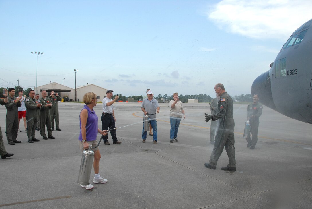 Chief Master Sgt. Greg Bell gets the traditional hosing off after completing his final flight aboard a C-130H Hercules aircraft.