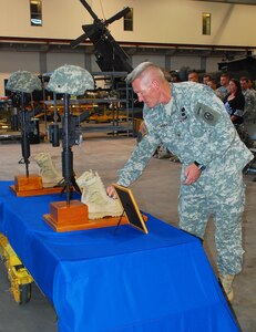 SOTO CANO AIR BASE, Honduras --  Col. Gregory Reilly, the Joint Task Force-Bravo commander, places coins at the battlefield crosses of two fallen 1-228th Aviation Regiment Soldiers during a memorial ceremony here Aug. 5. Sgt. Luis Brito and Sgt. Leodegario Lizárraga both died in a car accident July 31. (U.S. Air Force photo/Martin Chahin) 