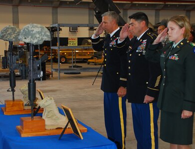 SOTO CANO AIR BASE, Honduras --  Paying their final respects to two fallen Soldiers, Lt. Col. James Kanicki, the 1-228th Aviation Regiment commander, Command Sgt. Maj. Lucio DeAnda, the 1-228th command sergeant major, and Capt. Erica Huston, the Headquarters and Headquarters Company commander, salute at the battlefield crosses during the memorial ceremony here Aug. 5. Sgt. Luis Brito and Sgt. Leodegario Lizárraga both died in a car accident July 31. (U.S. Air Force photo/Martin Chahin) 