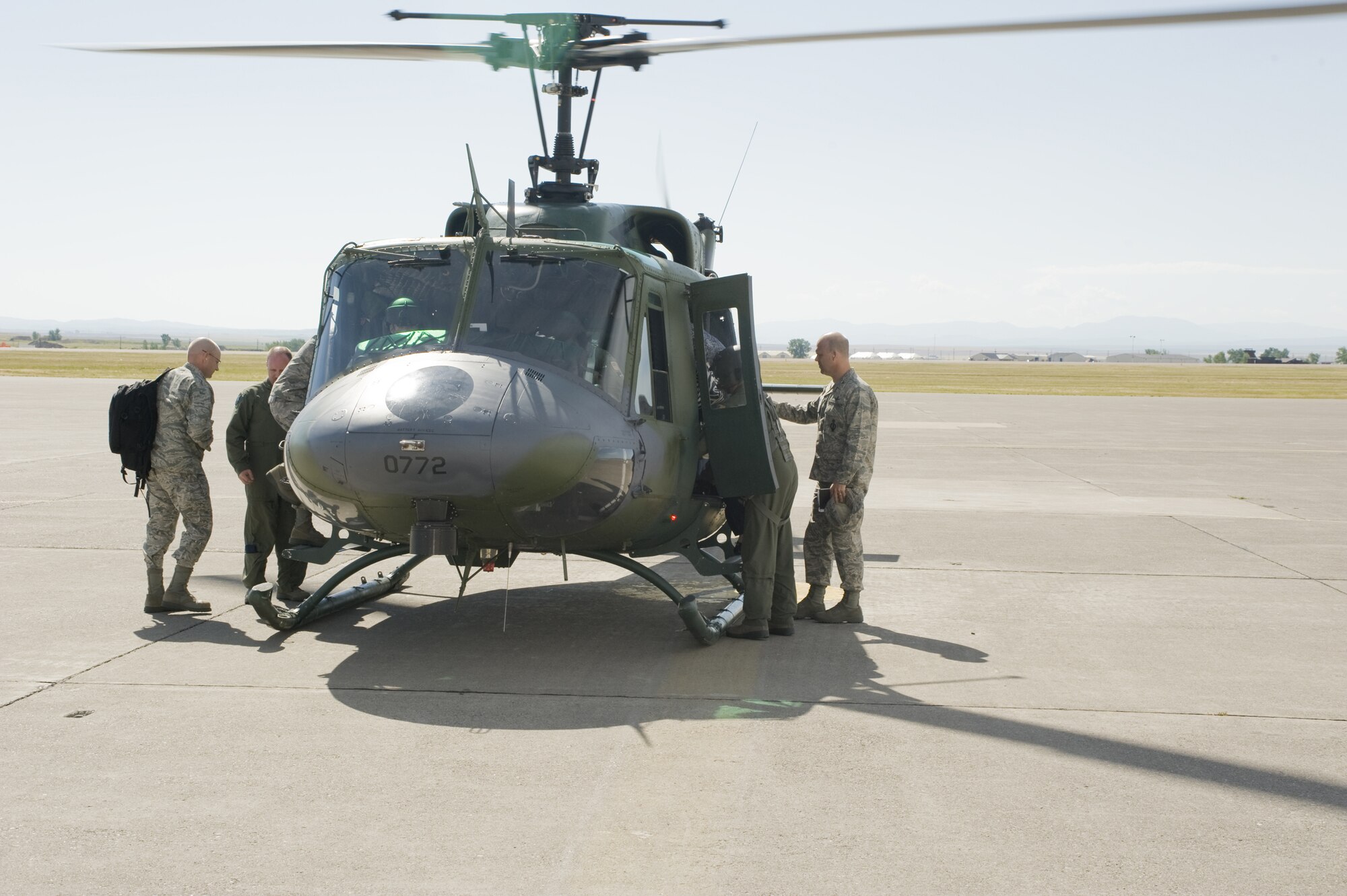 Col. Stephen Davis, far right, 341st Missile Wing vice commander, prepares to board a UH-1N Huey helicopter July 22 to escort a DV to the missile field for a  site visit. 
