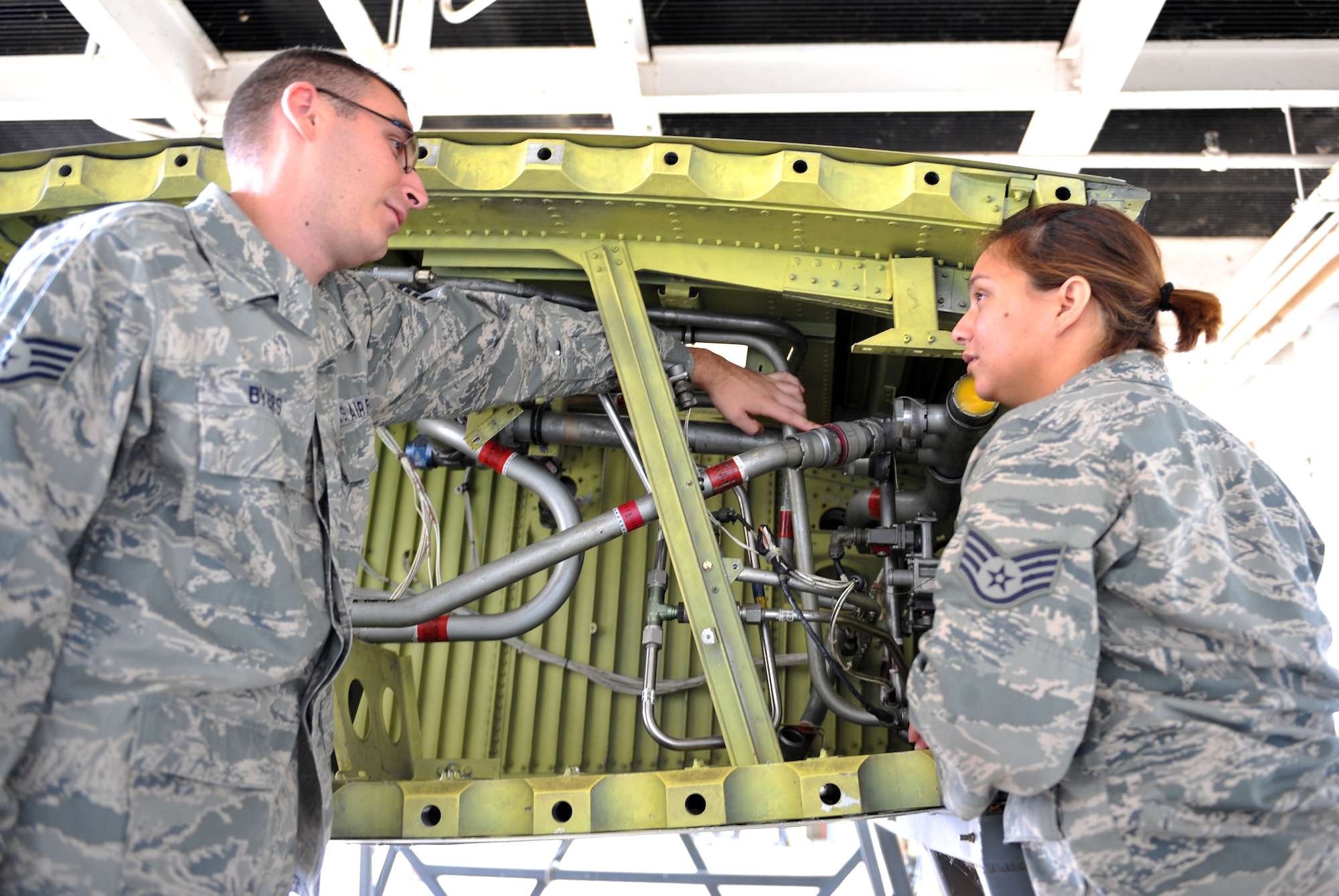 Staff Sgt. Jesse Byers (left) and Staff Sgt. Jennifer Peche, 19th Component Maintenance Squadron aircraft fuels systems repair craftsmen, discuss maintenance to fuel pipes and connections on a C-130 aircraft training wing July 16. The aircraft fuels systems repair Airmen use a three-man concept on all their jobs to ensure safety and timely repair to C-130 fuels systems. (U.S. Air Force photo by Senior Airman Steele C. G. Britton)