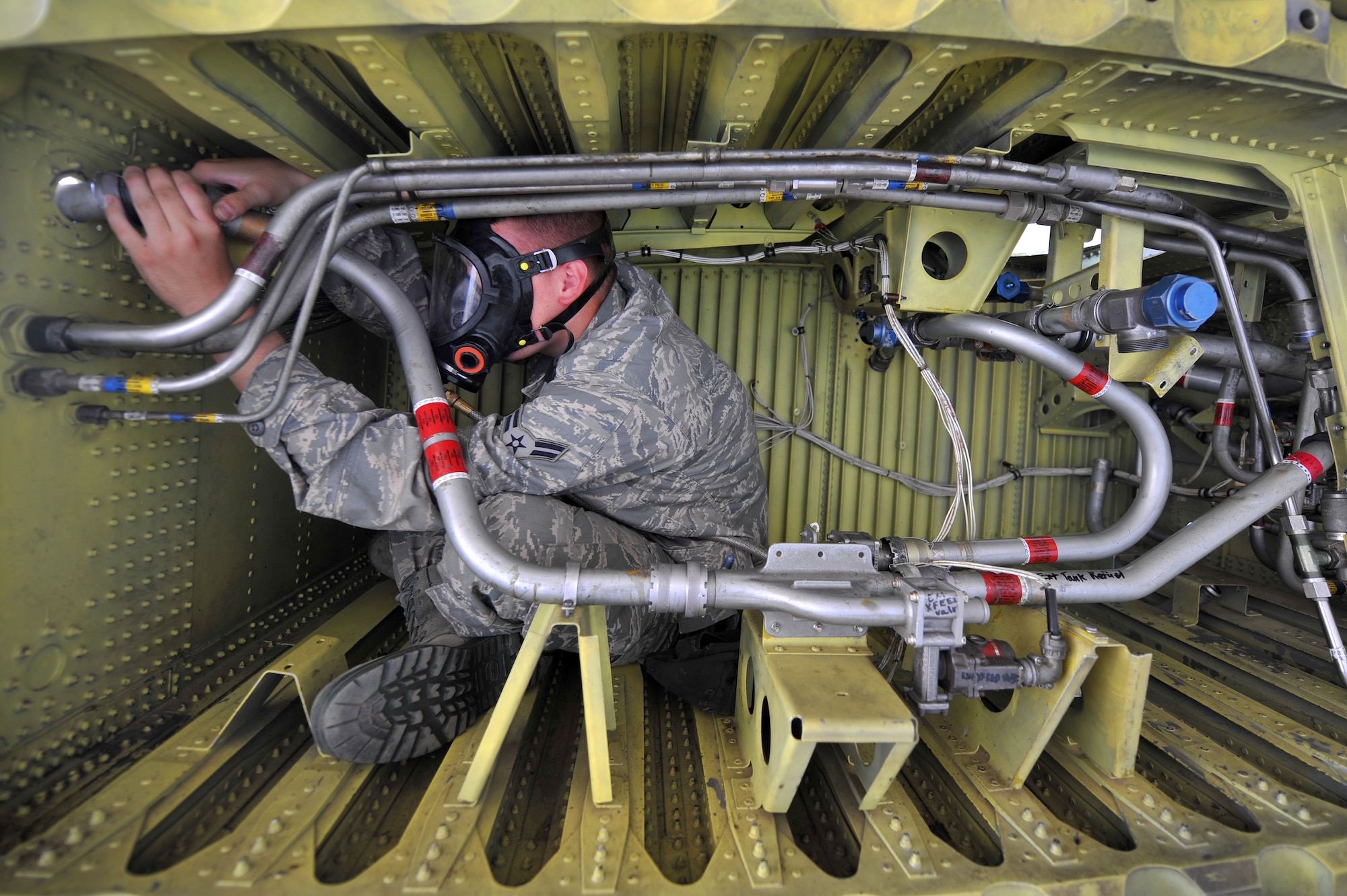 Airman 1st Class James Trainer, 19th Component Maintenance Squadron aircraft fuels systems repair apprentice, tightens a fuel pipe on a C-130 aircraft training wing July 16. The majority of an aircraft fuels systems repair Airman's duties take place in the wing of aircraft they maintain. (U.S. Air Force photo by Senior Airman Steele C. G. Britton)
