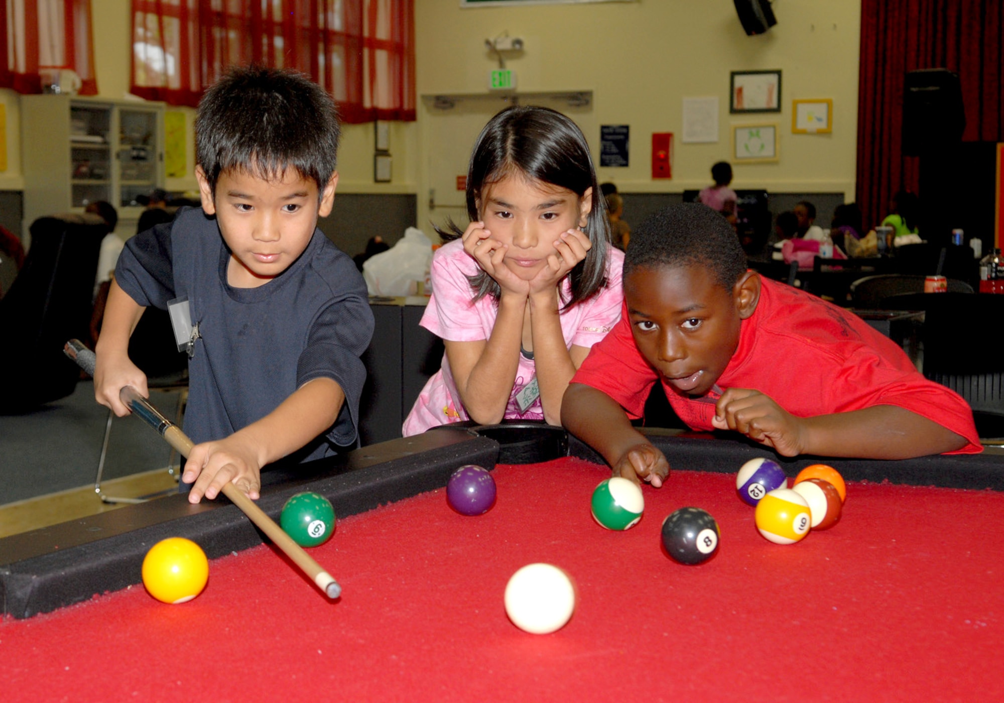Yuuri Kijyoka (left) prepares to shoot a pool ball while Ayaka Chibana (center) and Carlton Furman look on Aug. 5, 2010, at Kadena Air Base, Japan. (U.S. Air Force photo/Junko Kinjo)