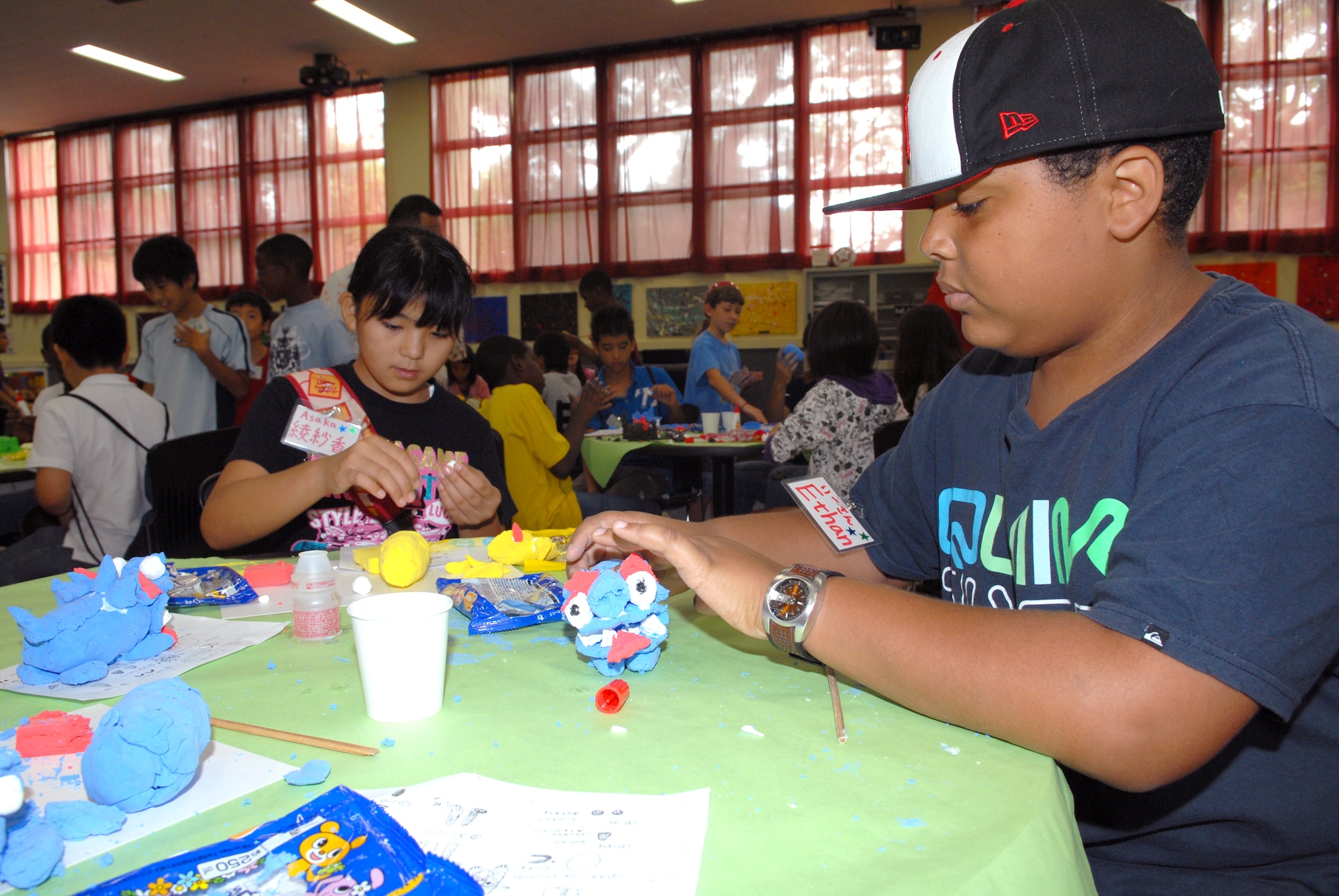 Asaka Tamaki (left) and partner Ethan Stewart work on their Shi-Shi dogs together Aug. 5, 2010, at Kadena Air Base, Japan. The two children took part with about 40 others in an international exchange program organized by the Kadena Youth Center and the Chatan Town Lions Club here. (U.S. Air Force photo/Junko Kinjo)