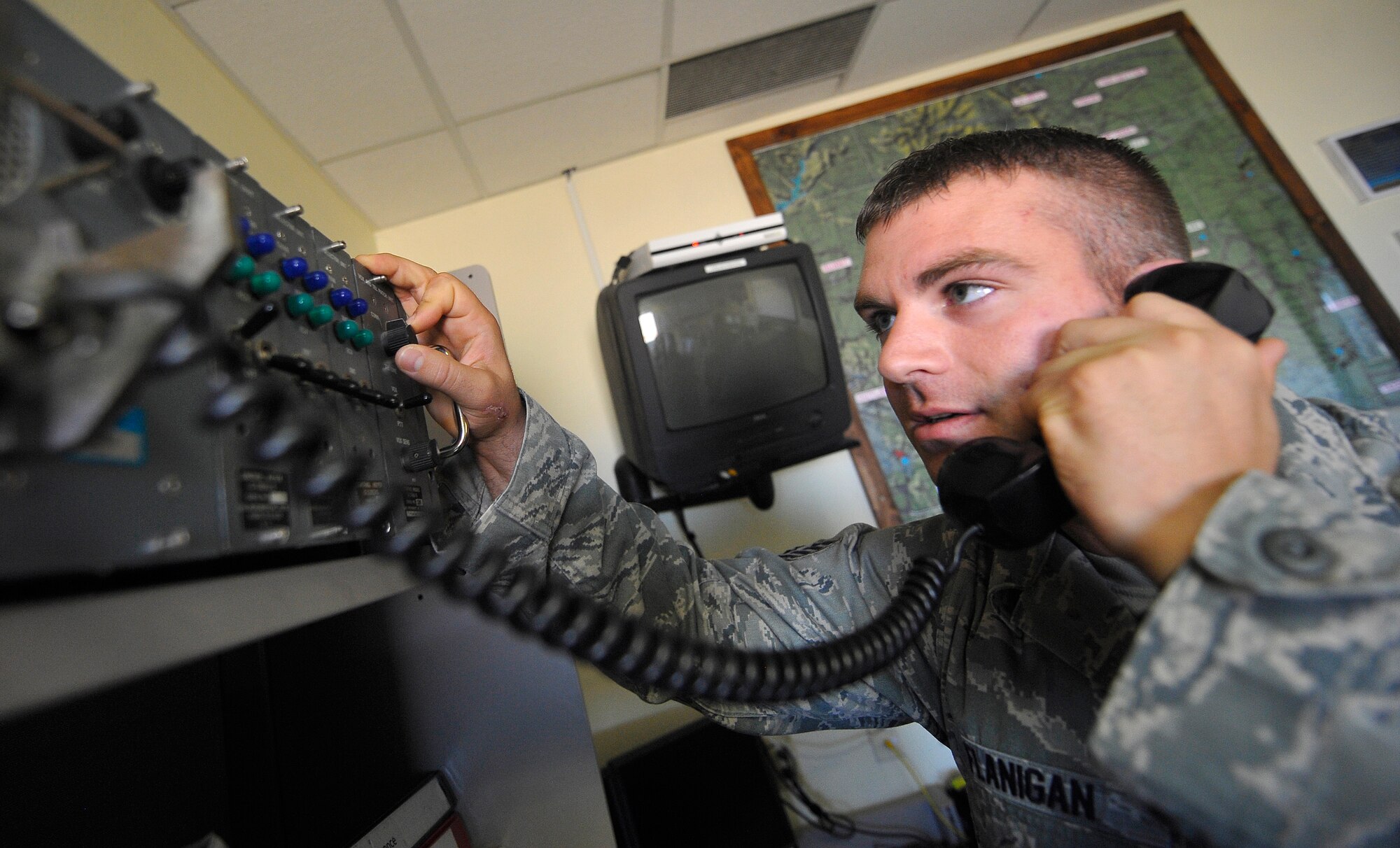 HOLLOMAN AIR FORCE BASE, N.M. -- Staff Sgt. Keith Flanigan, 49th Operations Support Squadron, uses a radio for Pilot to Metro Service whenever pilots call in to get current weather information for their destination airfield. Operational forecasters provide current and forecasted weather conditions, receive pilot weather reports and the hazards en route for pilots flying to and from the surrounding airfield. (U.S. Air Force photo by Senior Airman Veronica Stamps / Released)