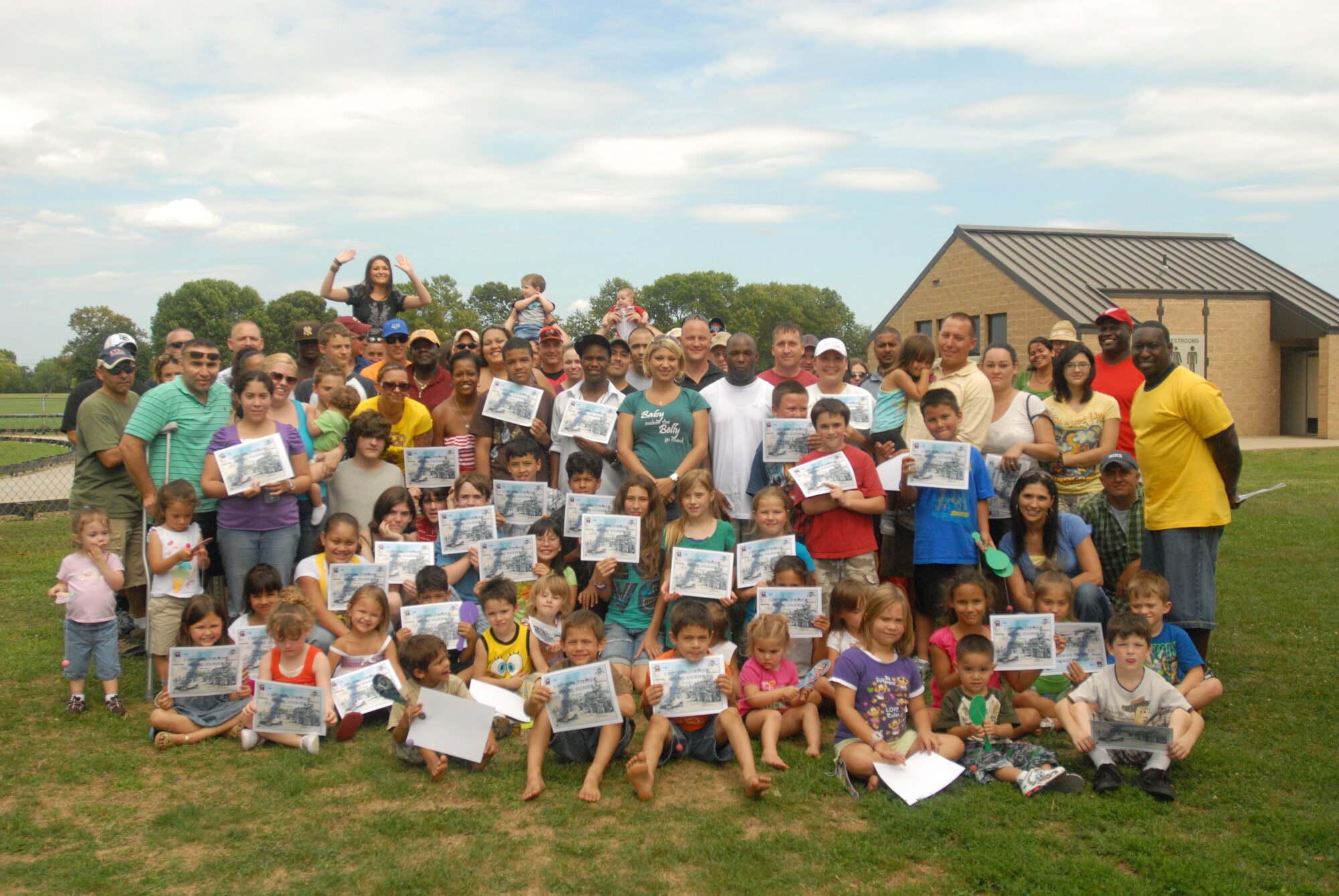 Soldiers of 1st Battalion, 307th Stryker Regiment, 72nd Field Artillery Brigade stand alongside their family members displaying their honorary Soldier certificates issued during the battalion organizational day August 2 at John Mann Park on Joint Base McGuire-Dix-Lakehurst. Families spent the day sharing food, fun and friendship - the 1/307th way. The unit was recently re-stationed here, and more than 40 families have relocated to JB MDL and the surrounding area since this time last year. (U.S. Army photo/ Capt. Antonia Greene)