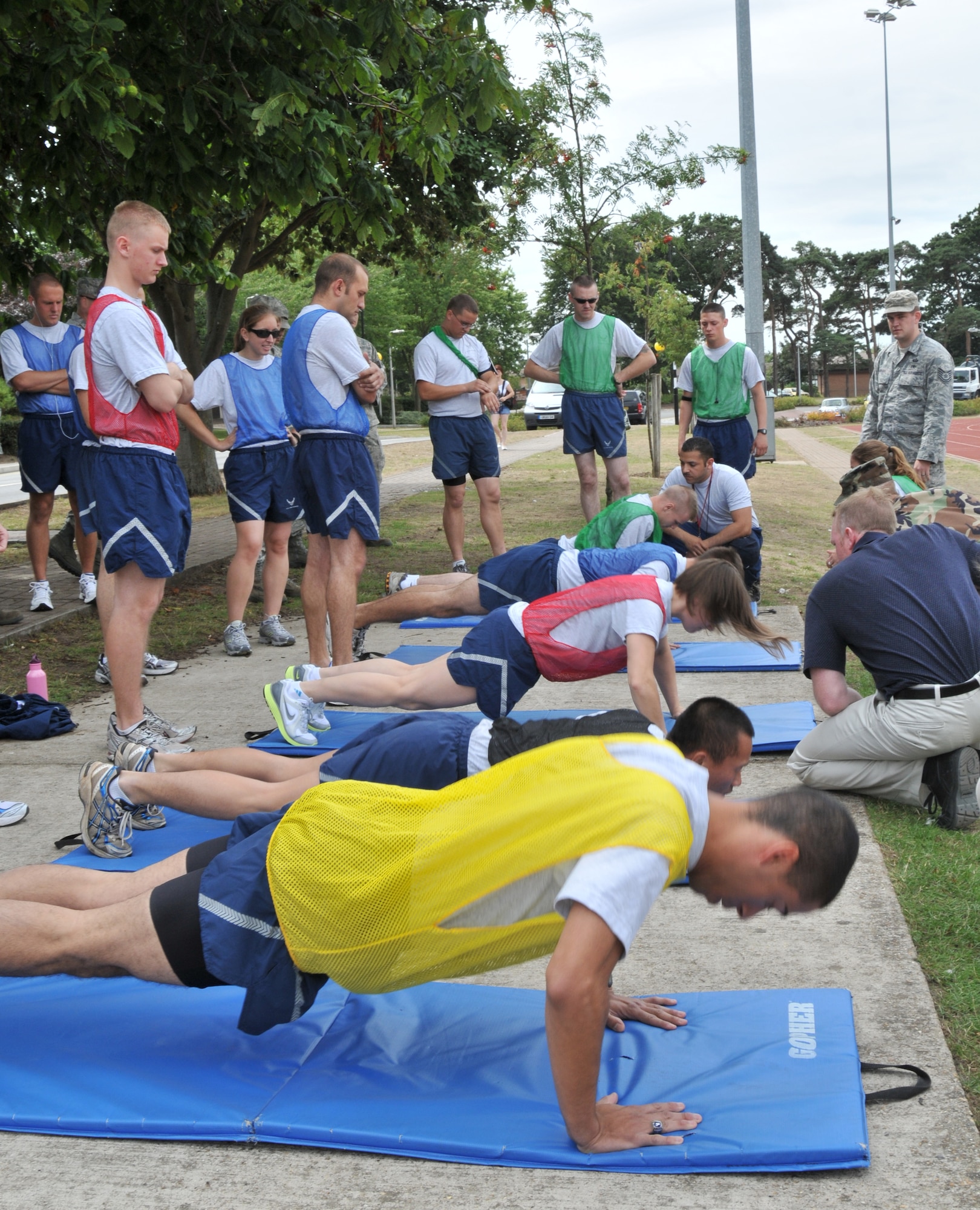 Airmen crank out push-ups during the Commander’s Trophy PT Challenge at the RAF Lakenheath running track Aug. 6. Each team member had to perform all three parts of the Air Force fitness test, including push-ups, sit-ups and 1.5 mile run. (U.S. Air Force photo/Senior Airman David Dobrydney)