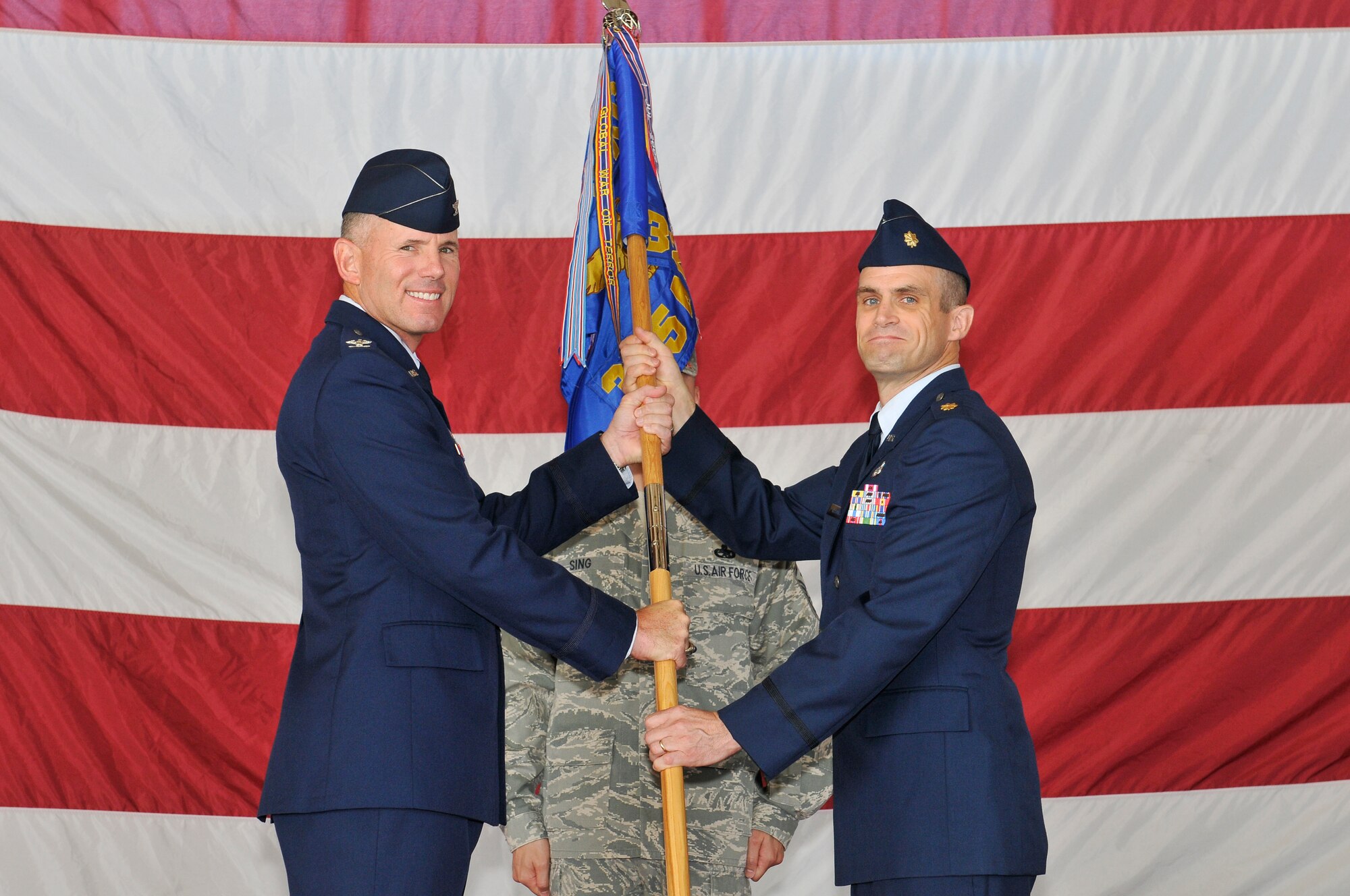 Major Andre Lecours accepts the 325th Maintenance Squadron guidon from Col. Craig Hall, 325th Maintenance Group commander, during a Change of Command ceremony July 29 at Tyndall. Major Lecours replaces Lt. Col. Aaron Rigdon as the new 325th MXS commander. (U.S. Air Force photo/Lisa Norman)