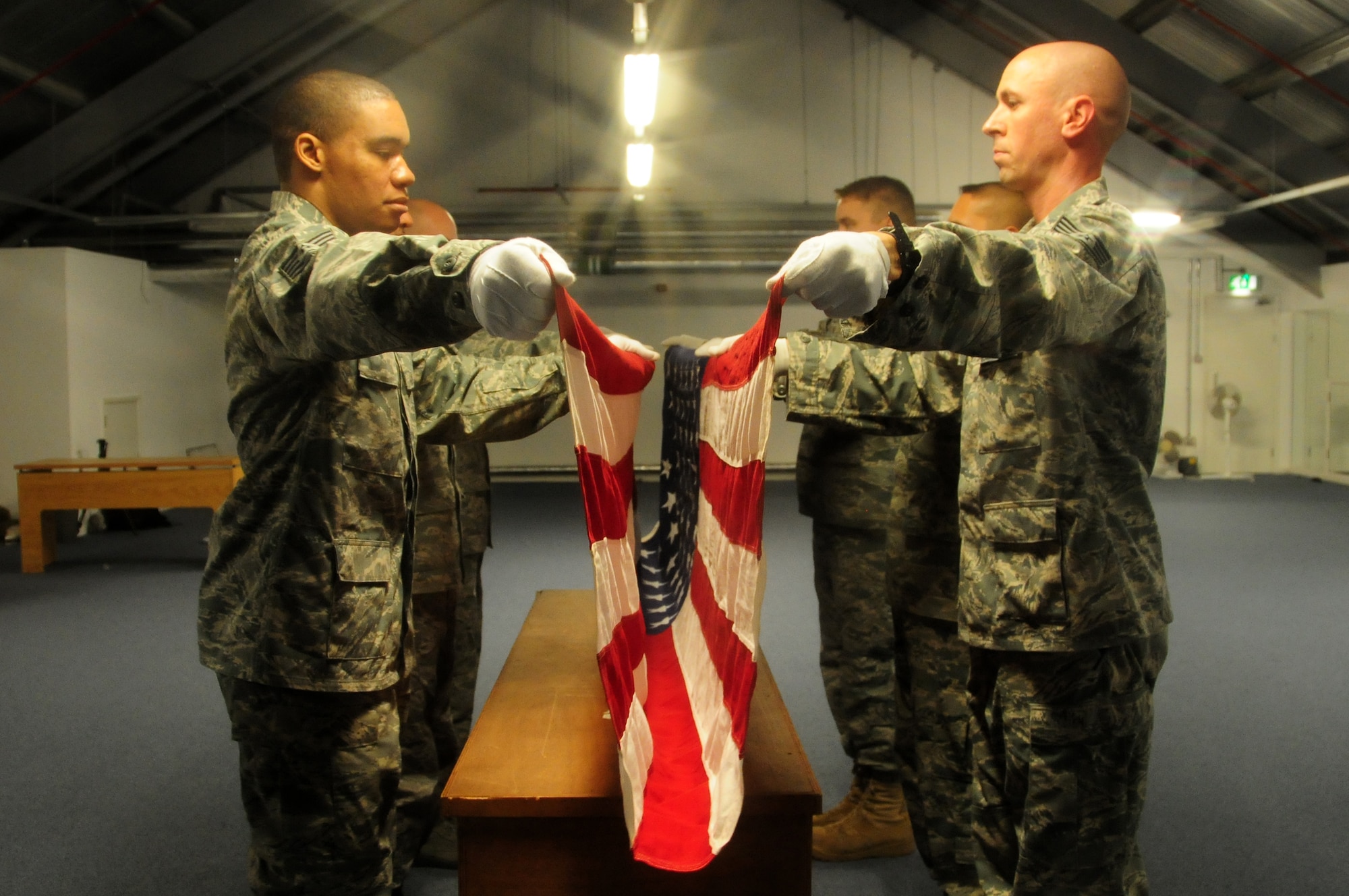 Honor guard members perform a six-man flag fold during practice at RAF Lakenheath Aug. 4. The RAF Lakenheath Honor Guard practices on the top floor of the Military Personnel Flight, building 977. (U.S. Air Force photo/Airman 1st Class Lausanne Morgan)