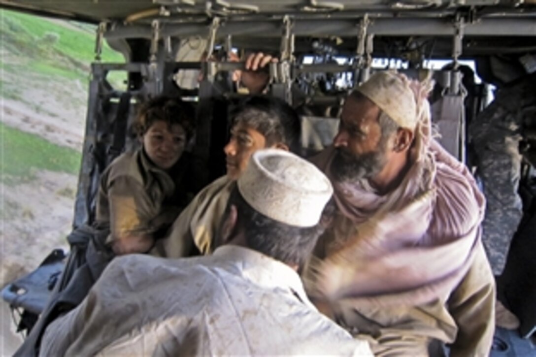 Afghans from Khost province, Afghanistan, sit in a UH-60 Black Hawk helicopter after being rescued from flood waters after multiple days of heavy rain, Aug.4, 2010. U.S. and Afghan forces responded to the emergency, rescuing 95 residents.