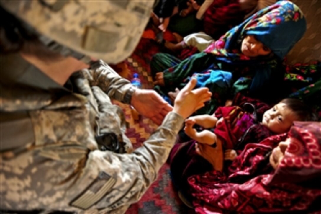 U.S. Army Staff Sgt. Jessica Walla examines the feet and legs of a baby girl while providing medical aid to the residents of Narin in Faryab province, Afghanistan, July 26, 2010. Walla is a medic assigned to the 10th Mountain Division's 3rd Battalion, 6th Field Artillery, 1st Brigade Combat Team.