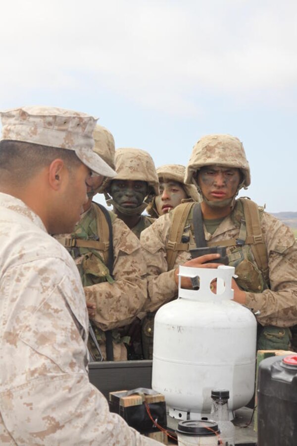 Pfc. Wendu Gebremichael, right, Platoon 3275, Co. M, listens as a field instructor lectures on how to determine if an object is an Improvised Explosive Device, and what to do if one is found, at Weapons Field Training Battalion, Camp Pendleton, Calif., July 27.