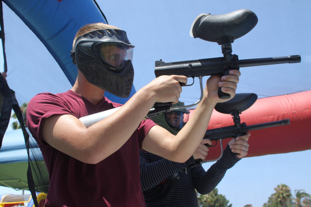 Lance Cpl. Ethan McDaniel, French horn player, Lance Cpl. Miguel Hernandez, clarinet player, Marine Band San Diego, shooting paintballs during the Family Summer Fun event on August 6.