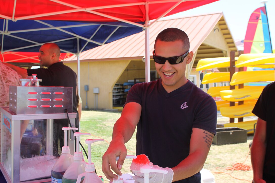 Lance Cpl. Abraham Lopez, clerk, assistant chief of staff recruiting, makes snow cones at the snow cone station during the Family Summer Fun event, Aug. 6.
