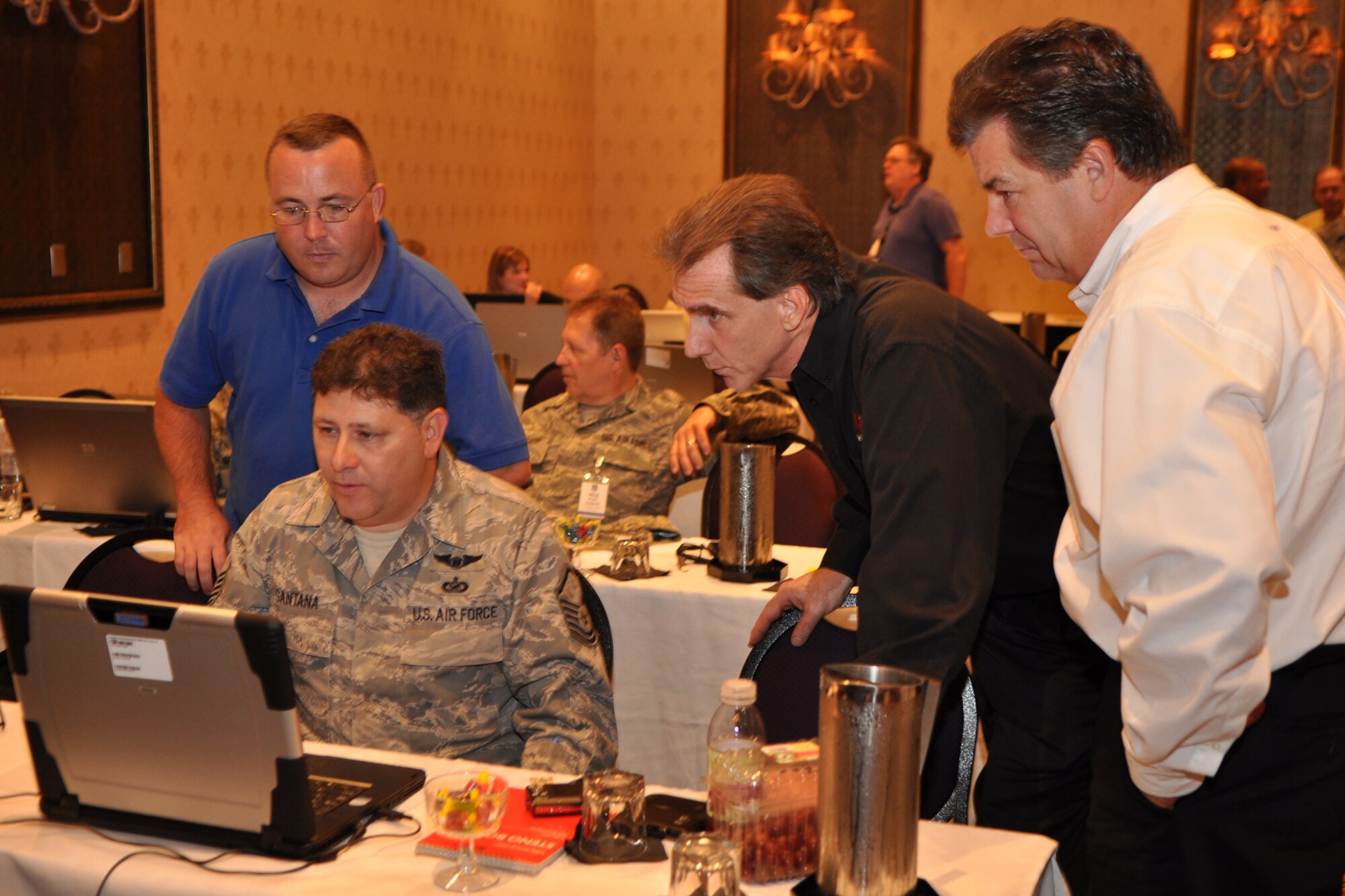Video experts, Joseph Mather, David K. Helmly Sr., and Trip Gotteli, take a moment to answer questions for Master Sgt. Roy Santana, after a video-editing session during the Air Force Reserve Command Public Affairs Conference at the Millennium Hotel in Minneapolis, Minn., July 19, 2010. Sergeant Santana is a photographer attached to the 4th Combat Camera unit at March Air Reserve Base, Calif. The conference, which is hosted by the AFRC every two years, allows public affairs representatives from throughout the AFRC to meet over a three-day period and receive training and information they can’t get anywhere else. (U.S. Air Force photo/Tech. Sgt. Jeff Walston)